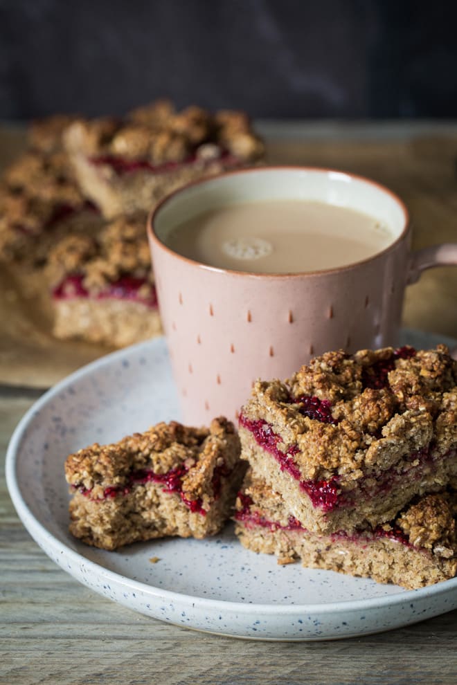 Oat and Raspberry Crumble Bars - a real breakfast treat! Yummy, filling oats kept deliciously moist with bananas, almond butter and home made chia raspberry jam. Vegan and Gluten Free | thecookandhim.com