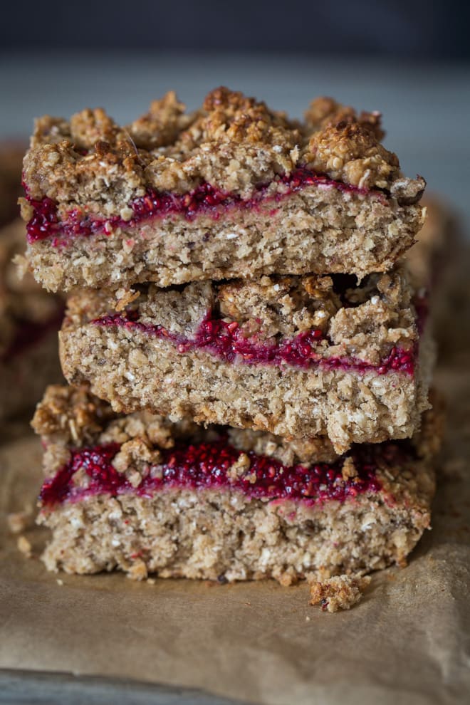 Oat and Raspberry Crumble Bars - a real breakfast treat! Yummy, filling oats kept deliciously moist with bananas, almond butter and home made chia raspberry jam. Vegan and Gluten Free | thecookandhim.com
