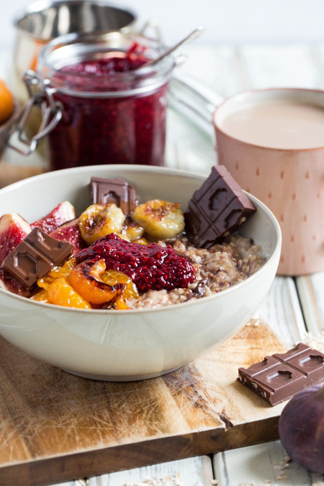 Chocolate and Raspberry Jam Porridge - rolled oats swirled with dark chocolate, topped with raspberry chia jam and maple roasted fruits. Oh and more chocolate of course! #veganbreakfast #porridge #oatmeal #veganchocolate | Recipe on thecookandhim.com