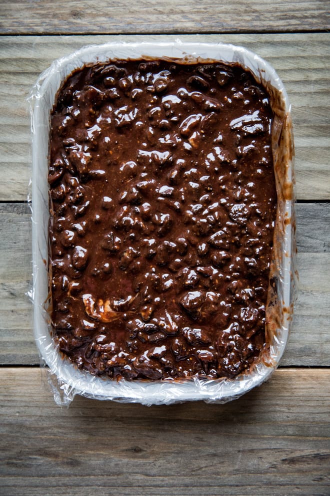 Vegan Chocolate Tiffin - crushed Oreos, dried fruits, golden syrup, rich dark chocolate and peanut butter all crammed into this festive treat! #veganchristmas #veganchocolate | Recipe on thecookandhim.com