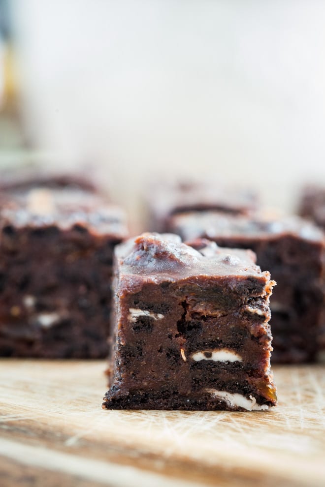 Vegan Chocolate Tiffin - crushed Oreos, dried fruits, golden syrup, rich dark chocolate and peanut butter all crammed into this festive treat! #veganchristmas #veganchocolate | Recipe on thecookandhim.com
