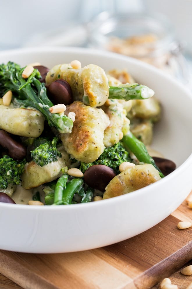 Gnocchi with Beans and Greens - gluten free pillowy gnocchi is easier to make than you might think! Just 2 base ingredients then some gentle spices for subtle flavour. Cooked up here with beautiful fresh green veggies, protein rich beans and a vegan creme fraiche sauce #veganrecipes #glutenfreerecipes #veganmealideas #meatfree | Recipe on thecookandhim.com