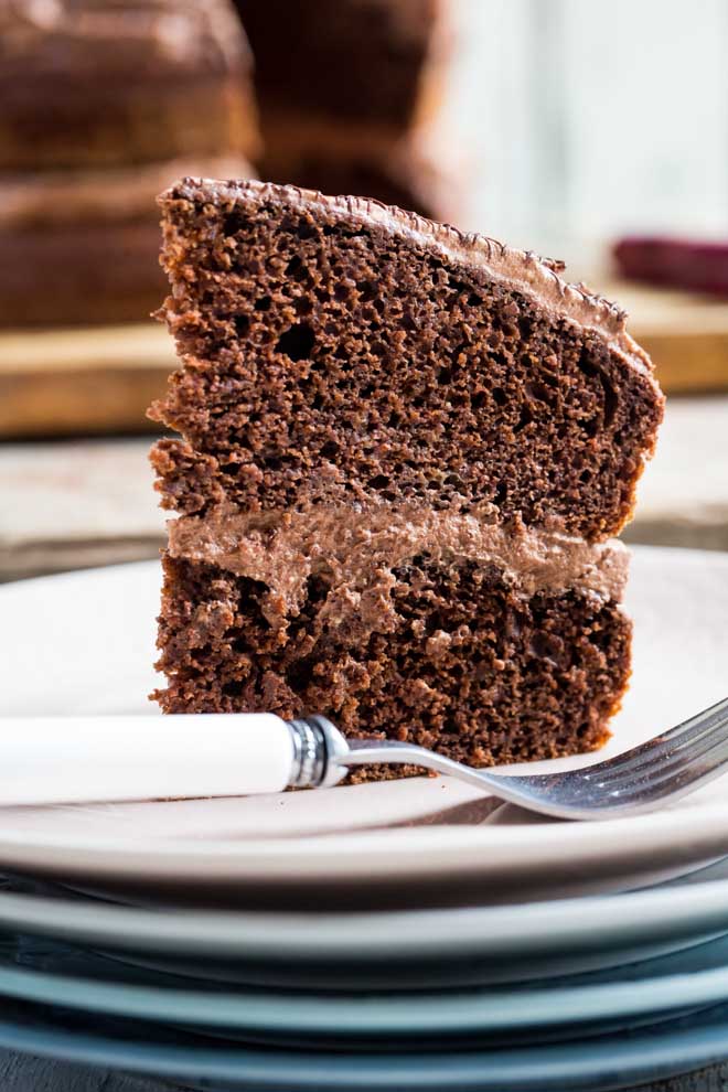 The yummiest Vegan Chocolate Fudge Cake, rich but light and divinely chocolatey with a creamy and fluffy vegan chocolate frosting #vegancake #veganchocolatecake #chocolatefudgecake #veganbaking | Recipe on thecookandhim.com