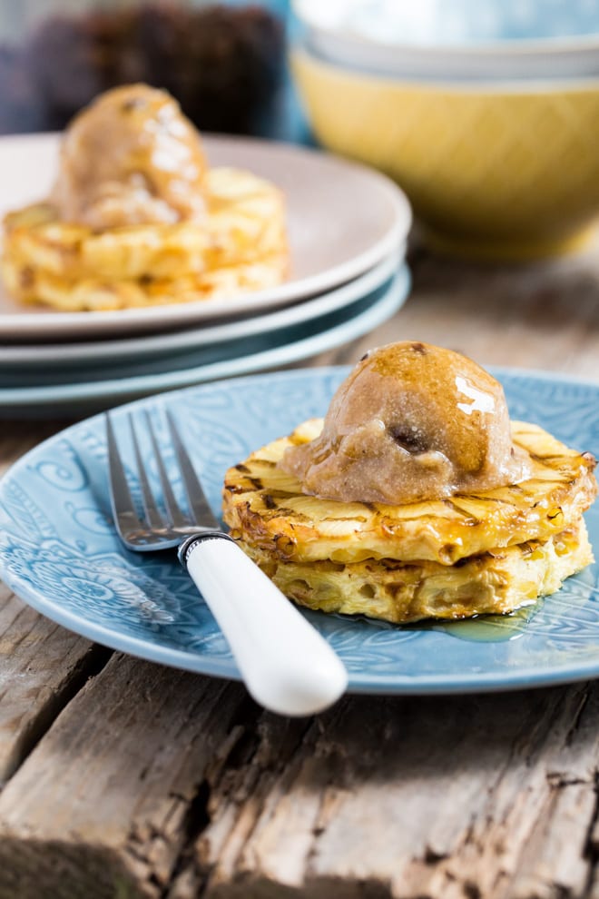 Warm, syrupy pineapple slices topped with a vegan rum and raisin ice cream - the perfect summer recipe! #veganicecream #vegandesserts #pineapple #rumandraisin #dairyfree | Recipe on thecookandhim.com