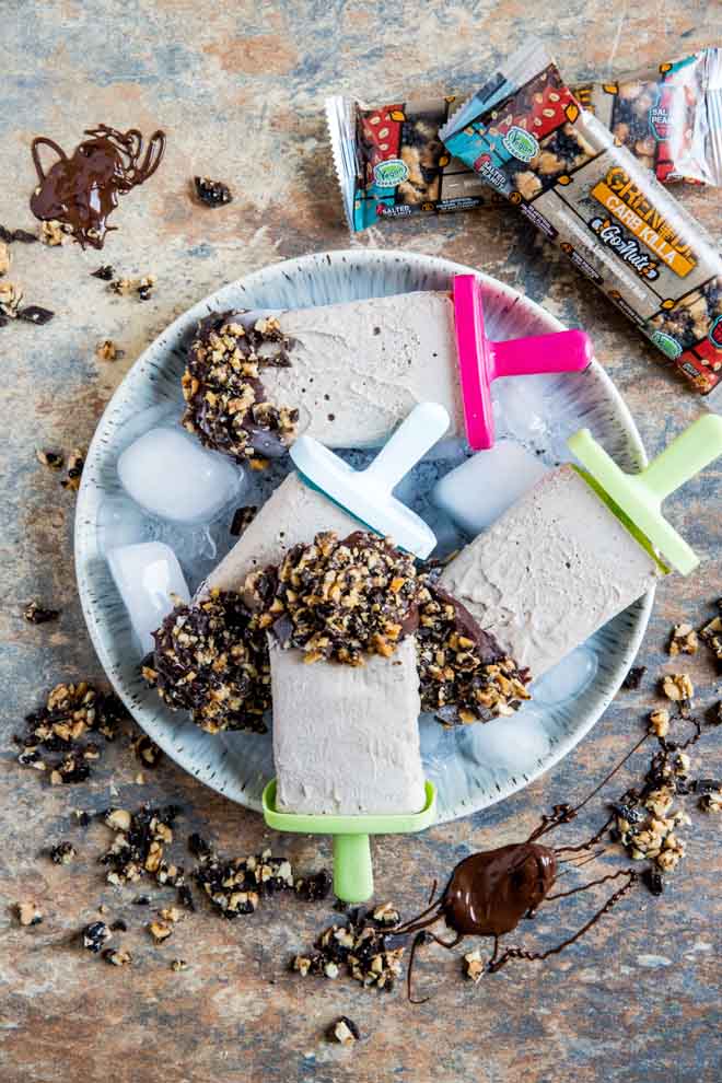 These vegan ice cream pops are smooth, creamy and super easy to make! We've also got vegan protein bars crushed into the ice cream and nibbly chunks on the rich chocolate coating. The perfect healthy summer treat! #veganrecipes #veganicecream #veganprotein #healthysnack | Recipe on thecookandhim.com