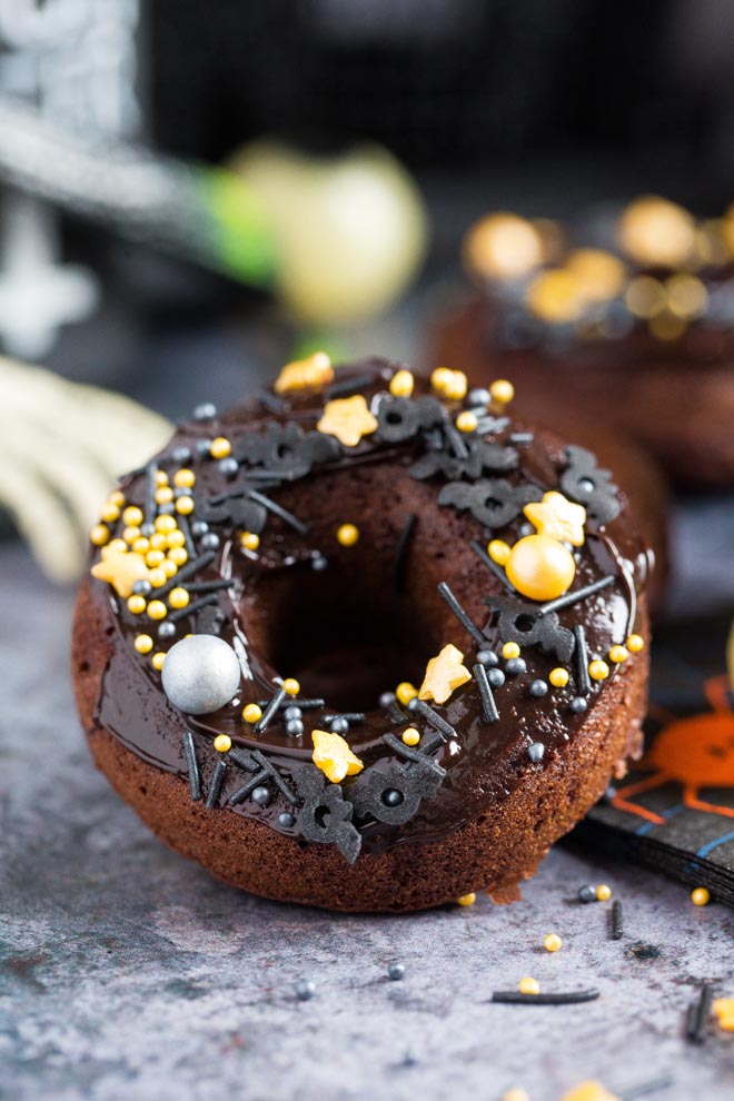 Spook your guests with these frightfully good Halloween donuts! These baked donuts are full of warming spice and chocolate orange yummies! #halloween #halloweenfood #halloweendonuts #veganhalloween | Recipe on thecookandhim.com