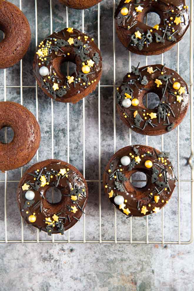 Spook your guests with these frightfully good Halloween donuts! These baked donuts are full of warming spice and chocolate orange yummies! #halloween #halloweenfood #halloweendonuts #veganhalloween | Recipe on thecookandhim.com