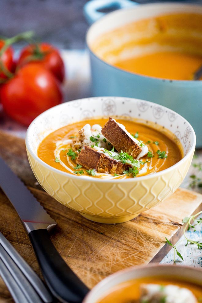 Thick, rich and delicious roasted tomato soup! Packed full of (hidden) roasted veggie flavour and so simple to make - even the vegan cheesy croutons! #tomatosoup #tomatosouprecipe #veganrecipes #vegansoup | Recipe on thecookandhim.com