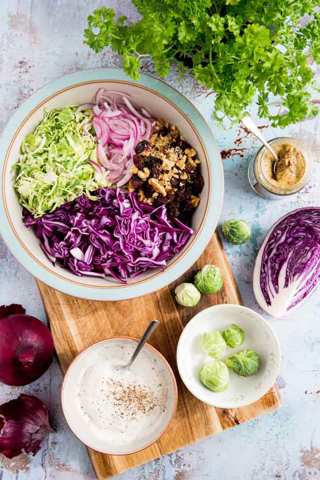 Creamy vegan winter slaw made with red cabbage, Brussels sprouts, red onion, crunchy walnuts, jewel like sultanas and a homemade vegan mustard mayonnaise! #veganrecipes #coleslaw #winterslaw #veganmayonnaise #veganmayo | Recipe on thecookandhim.com
