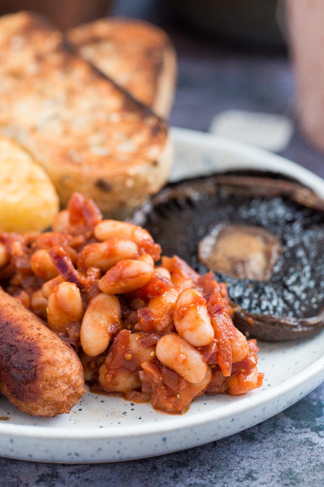 Both sweet and savoury with a spicy kick, these homemade baked beans are made with just a few store cupboard ingredients but are so versatile and absolutely packed with flavour! #bakedbeans #veganrecipes #spicybeans #comfortfood | Recipe on thecookandhim.com