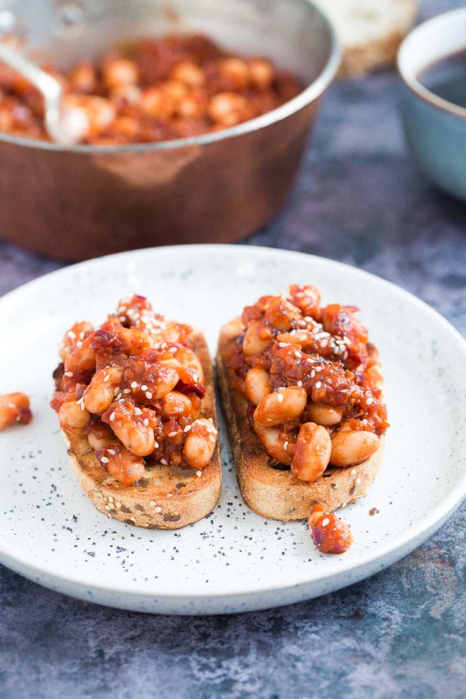Both sweet and savoury with a spicy kick, these homemade baked beans are made with just a few store cupboard ingredients but are so versatile and absolutely packed with flavour! #bakedbeans #veganrecipes #spicybeans #comfortfood | Recipe on thecookandhim.com