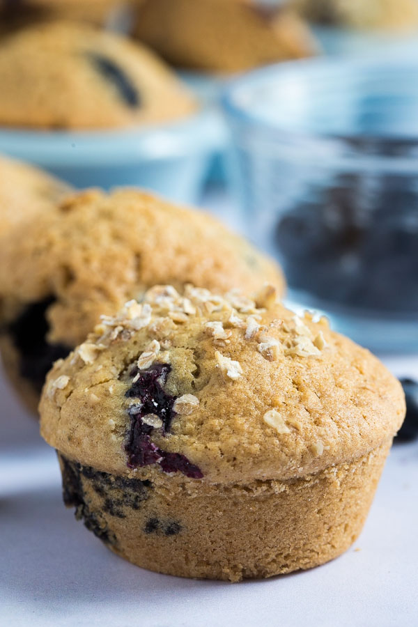 These vegan blueberry muffins are deliciously light and dangerously moreish. We can't just stop at one! They're also ridiculously easy to make too! #veganmuffins #blueberrymuffins #veganrecipes #muffinrecipe #blueberrymuffinrecipe #veganbaking | Recipe on thecookandhim.com