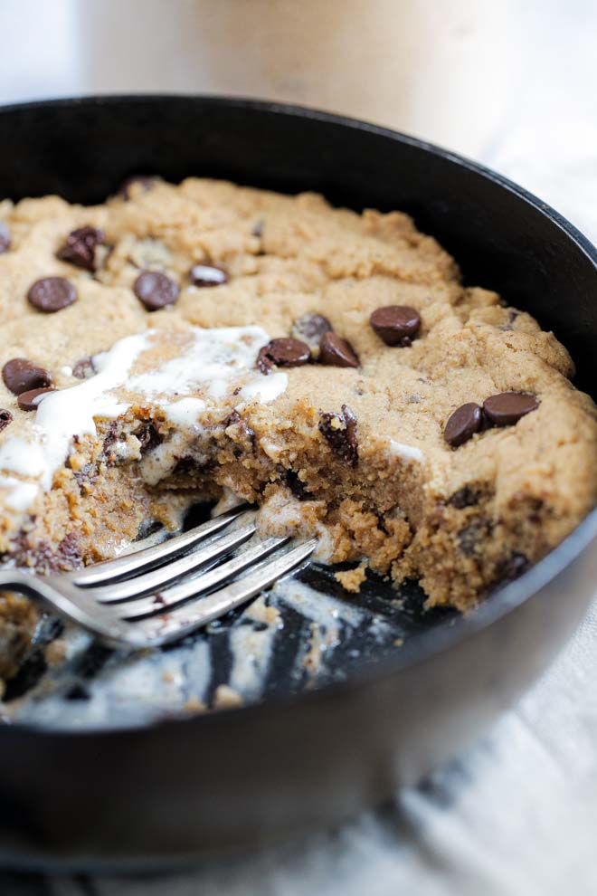 Warm, gooey and delicious this vegan chocolate chip skillet cookie is easily made in advance, baked fresh and a real crowd favourite! #skilletcookie #vegancookie #pizookie #veganrecipes #veganbaking #dairyfree | Reipe on thecookandhim.com