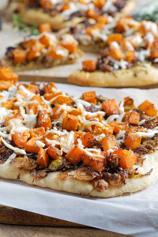 Simple but delicious this autumn harvest pizza is full of all the best seasonal flavours, herbs and gentle spices. Top with tangy vegan cheese for a comfort food favourite! #veganpizza #pizza #vegancheese #plantbasedpizza #dairyfreepizza #meatfreepizza | Recipe on thecookandhim.com