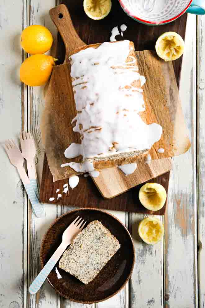Zingy lemons and light poppy seeds combine perfectly in this delicate but moist vegan lemon poppy seed cake. Topped with a drizzle of sweet icing you'll be making this cake again and again! #lemoncake #lemonpoppyseedcake #lemonloaf #vegancake #dairyfree #eggfreecake #veganbaking #nondairymilk #veganmilk | Recipe on thecookandhim.com