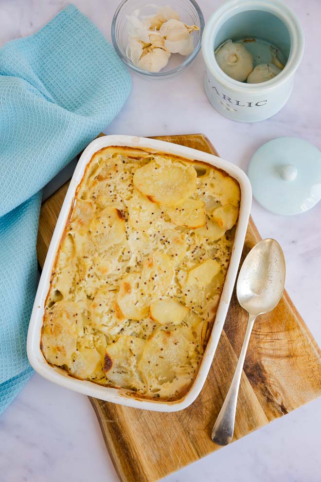 Layers of leek and potato with a rich garlic, rosemary and mustard cream sauce takes these vegan dauphinoise from delicious to extraordinary! So simple to make and so satisfying to eat! #veganside #scallopedpotatoes #veganscallopedpotatoes #veganpotatodish #vegandauphinoise #glutenfree #vegan #veganrecipes #dairyfree #plantbased | Recipe on thecookandhim.com