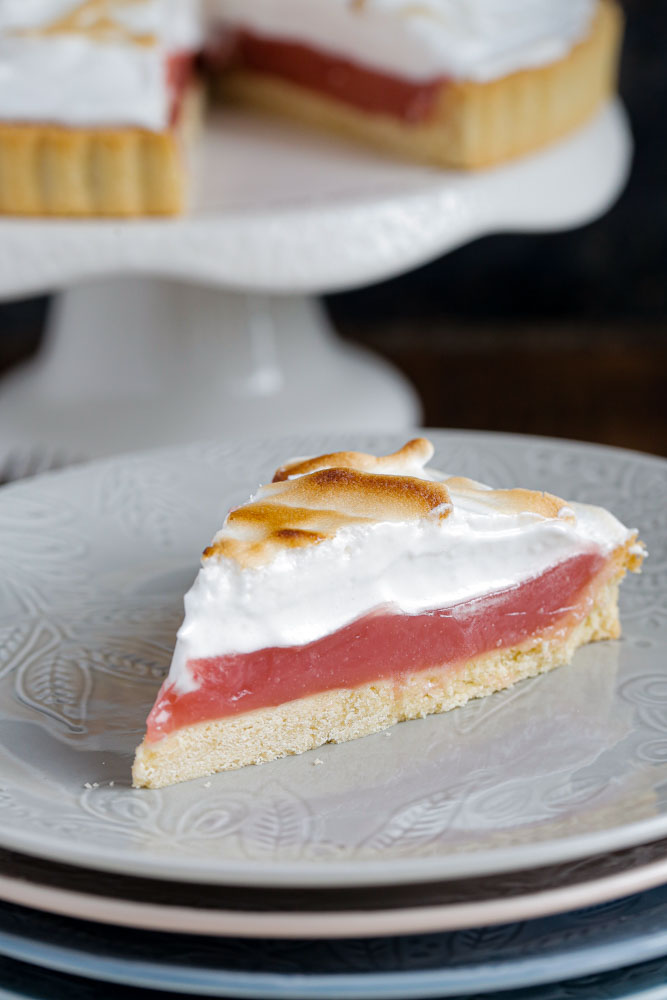 A deliciously summery vegan twist on classic lemon this raspberry meringue pie delivers slice after slice of pretty pink heaven! #veganbaking #veganmeringue #aquafaba #meringuepie #vegandessert #pie | Recipe on thecookandhim.com