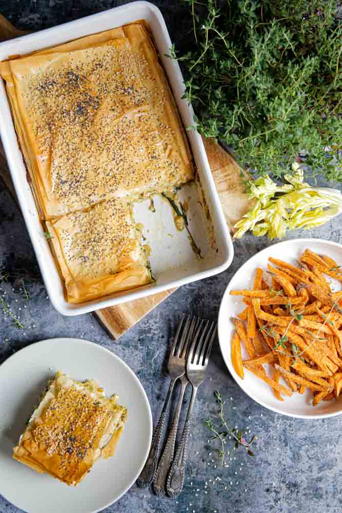 Crisp, ruffled pastry tops this filo pie. Packed with creamy leeks, spinach, black garlic and tofu as well as rich, hearty flavours! This pie is a great vegan roast dinner alternative, is easy to prepare and can be served with anything from roast veggies to a simple seasonal salad for a truly versatile meal! Recipe on thecookandhim.com #filo #filorecipes #filopastry #vegan #veganpie #vegandinnerideas #veganchristmas