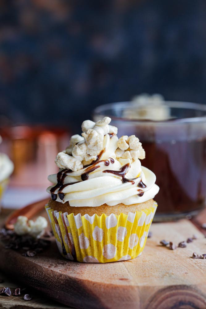 Full of buttery caramel flavour in both the deliciously soft sponge and fluffy buttercream frosting these cupcakes are perfect for both beginner and expert vegan bakers! They make a wonderful afternoon treat or autumn picnic dessert! Top with salted caramel popcorn and chocolate drizzle for real indulgence! | Recipe on thecookandhim.com #caramelcupcakes #saltedcaramel #cupcakes #vegancupcakes #veganbaking #veganbuttercream #veganrecipes #autumnrecipes #fallrecipes