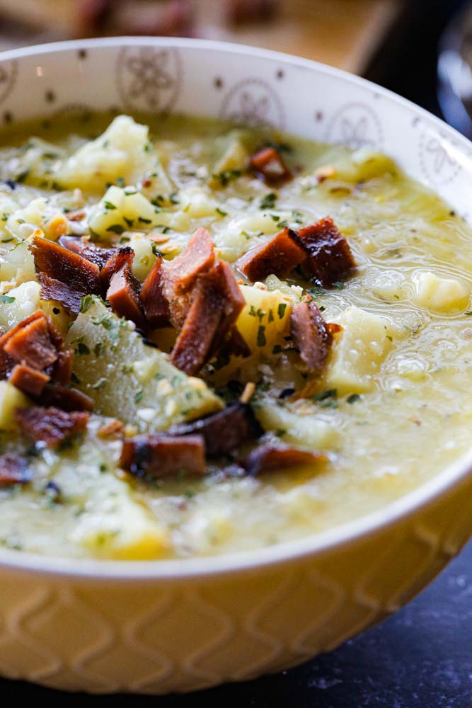 Baby potatoes, fragrant leeks, herbs, garlic, apple cider and vegan cheese are all in this easy, rich and hearty soup. Add crumbled vegan bacon bits for a crispy, salty topping, turning this leek and potato soup into pure comfort food heaven! Recipe on thecookandhim.com | #leekandpotatosoup #homemadesoup #healthysoup #vegansoup #soup #souprecipe #leekrecipes #potatorecipes #wintersoup