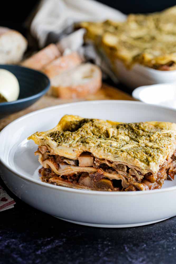 Deliciously vegan pumpkin lasagne with a dash of wine, tonnes of veggies and flavour. Topped with a creamy vegan white sauce swirled with a homemade, garlicky sage and walnut pesto! Recipe on thecookandhim.com | #pumpkinrecipes #veganlasagne #pumpkinlasagne #veganrecipes #fallrecipes #autumnrecipes #veganpesto #easypesto #vegetarian #dairyfree #meatfree