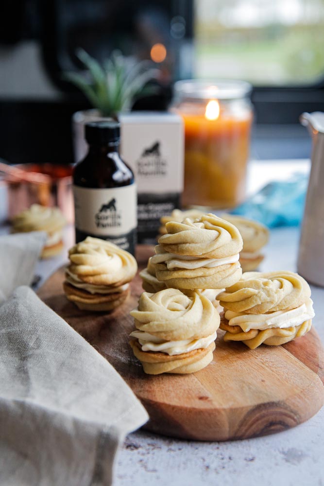 Soft, buttery and melt in the mouth these vegan vanilla sandwich cookies filled with vanilla buttercream are an easy to bake delicate little treat! Recipe on thecookandhim.com #vegancookies #veganbaking #vanillacookies #sandwichcookies #vanilla #veganrecipes