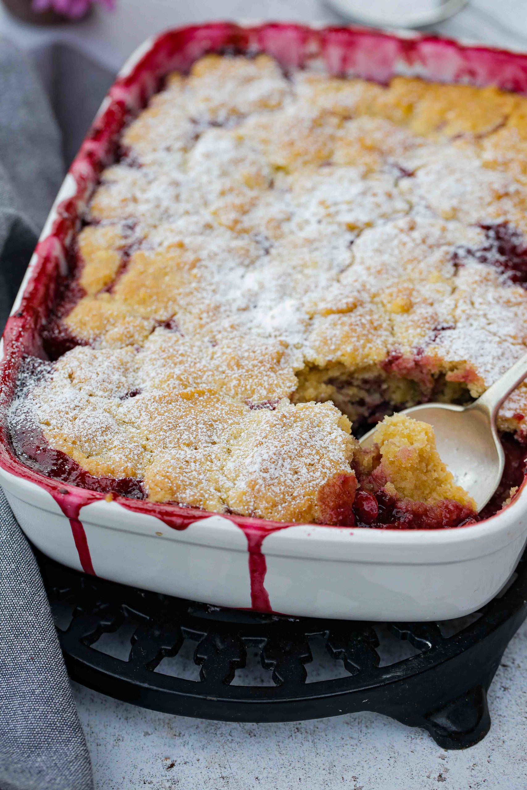 Ripe quince and juicy berries cooked in a sticky sweet syrup then topped with a rich, buttery and crisp cobbler. Perfect for using up any frozen summer berries. Just add vanilla ice cream for the perfect autumn dessert | Recipe on thecookandhim.com #veganbaking #vegandessert #veganrecipes #cobblerrecipe #fruitcobbler #quincerecipes