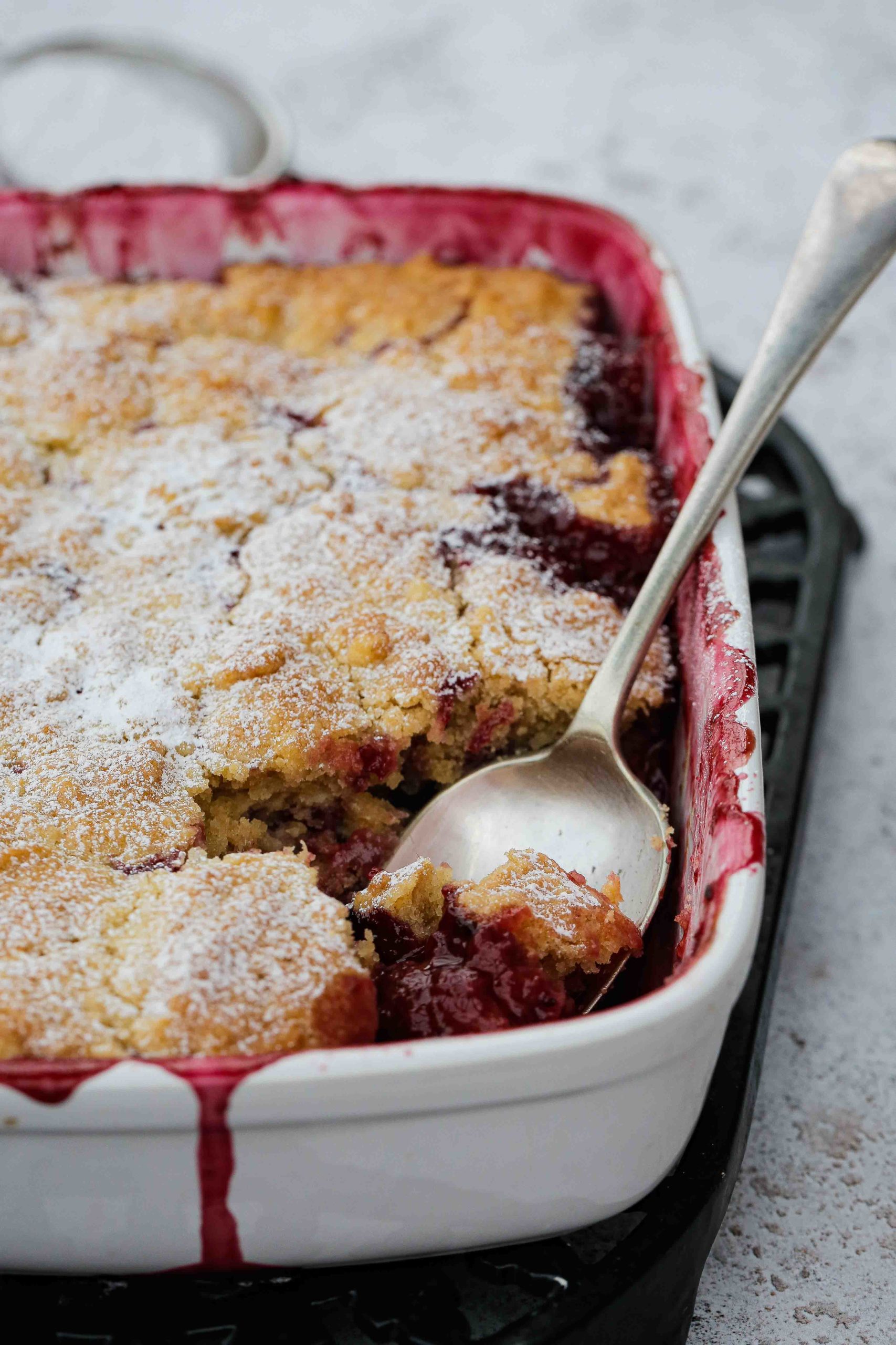 Ripe quince and juicy berries cooked in a sticky sweet syrup then topped with a rich, buttery and crisp cobbler. Perfect for using up any frozen summer berries. Just add vanilla ice cream for the perfect autumn dessert | Recipe on thecookandhim.com #veganbaking #vegandessert #veganrecipes #cobblerrecipe #fruitcobbler #quincerecipes