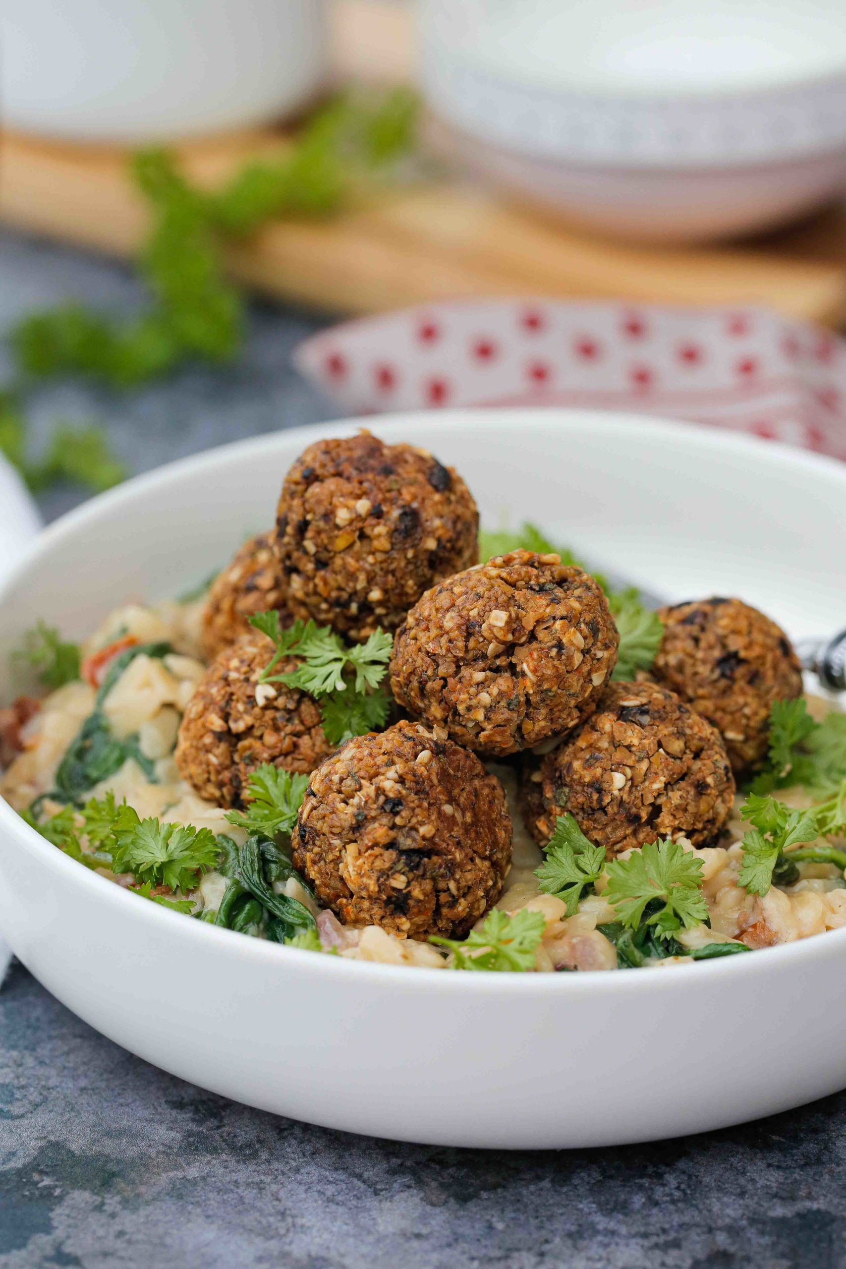 Crispy baked vegan meatballs with creamy orzo packed with spinach, sun dried tomatoes and lots of delicious flavour | Recipe on thecookandhim.com #veganmeatballs #veganpasta #vegandinner #veganmealidea #orzopasta #thecookandhim