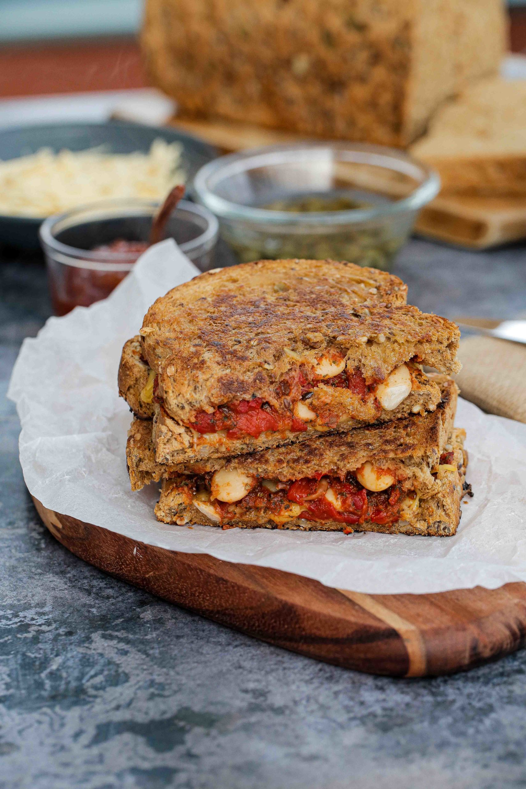 Tangy beans and vegan smoked applewood are packed in making these humble cheese toasties the ultimate comfort food! | Recipe on thecookandhim.com #cheesetoasties #vegancheese #vegansandwich #grilledcheese