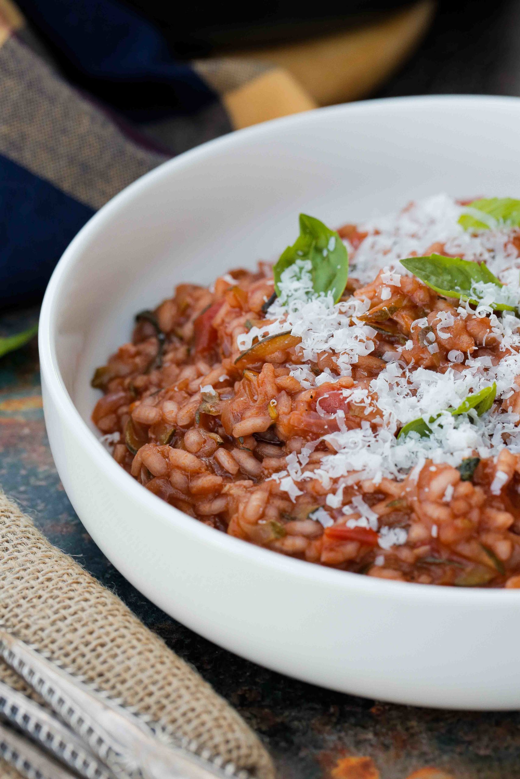 A super easy and comforting tomato risotto recipe packed with extra veggies and lots of flavour. Made with basic pantry ingredients and all cooked in one pan for an easy and delicious midweek dinner | Recipe on thecookandhim.com #risotto #veganrecipes #vegetarianrecipe #onepot #glutenfree #vegandinners