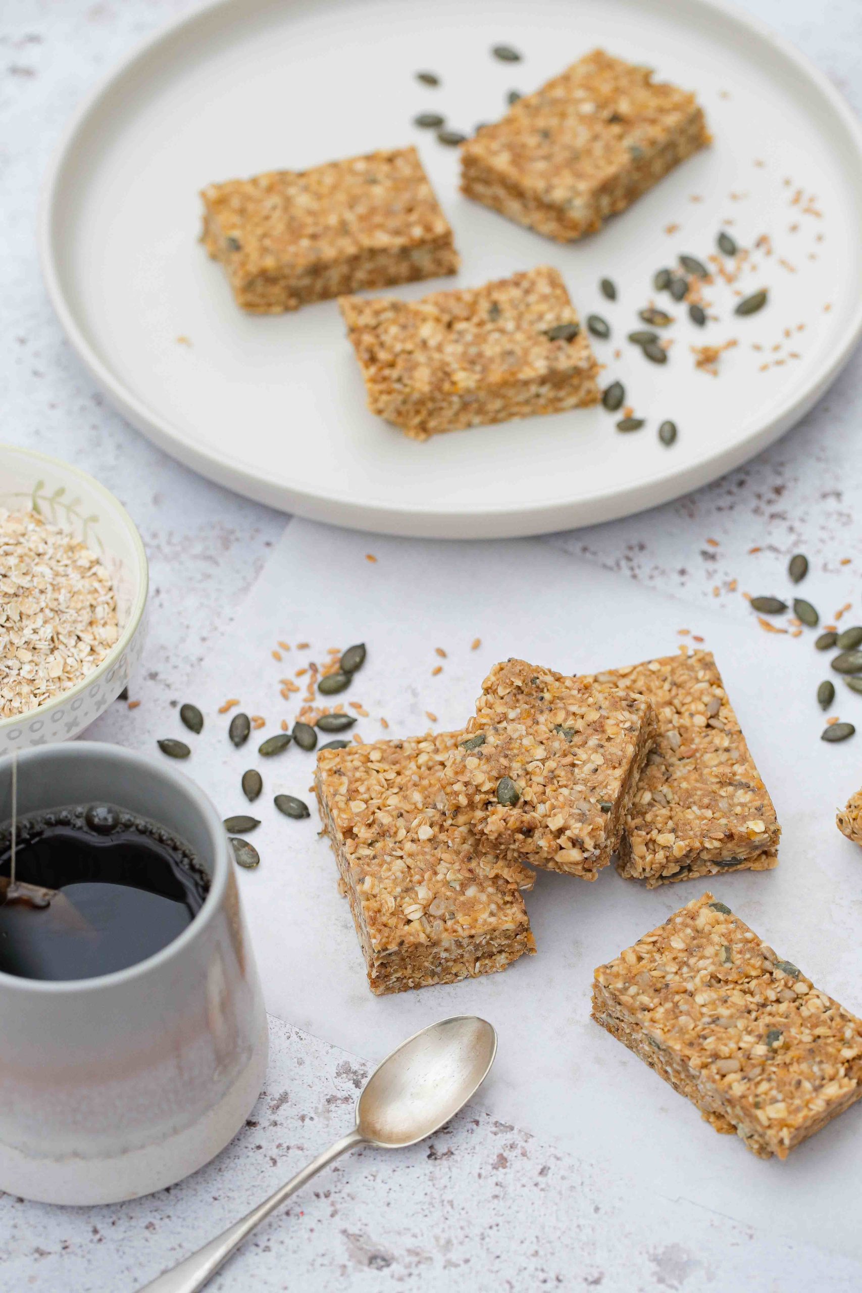 EASY no bake homemade peanut butter oat bars - full of seeds, nuts and dried fruits. Refined sugar free but sweet and chewy and perfect for a quick breakfast or snack! Vegan and gluten free recipe on thecookandhim.com #nobakebars #peanutbutterbars #granolabars