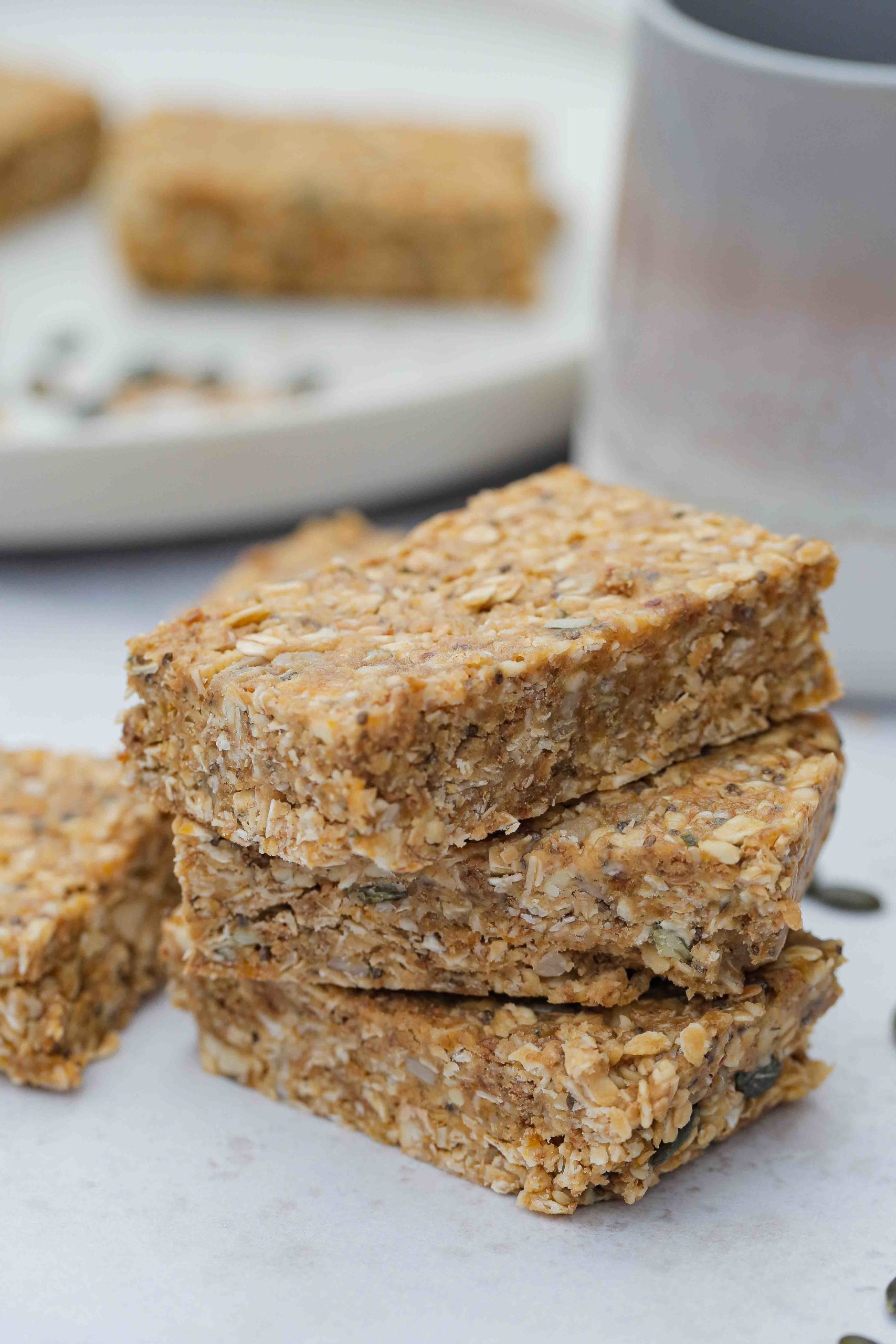 EASY no bake homemade peanut butter oat bars - full of seeds, nuts and dried fruits. Refined sugar free but sweet and chewy and perfect for a quick breakfast or snack! Vegan and gluten free recipe on thecookandhim.com #nobakebars #peanutbutterbars #granolabars