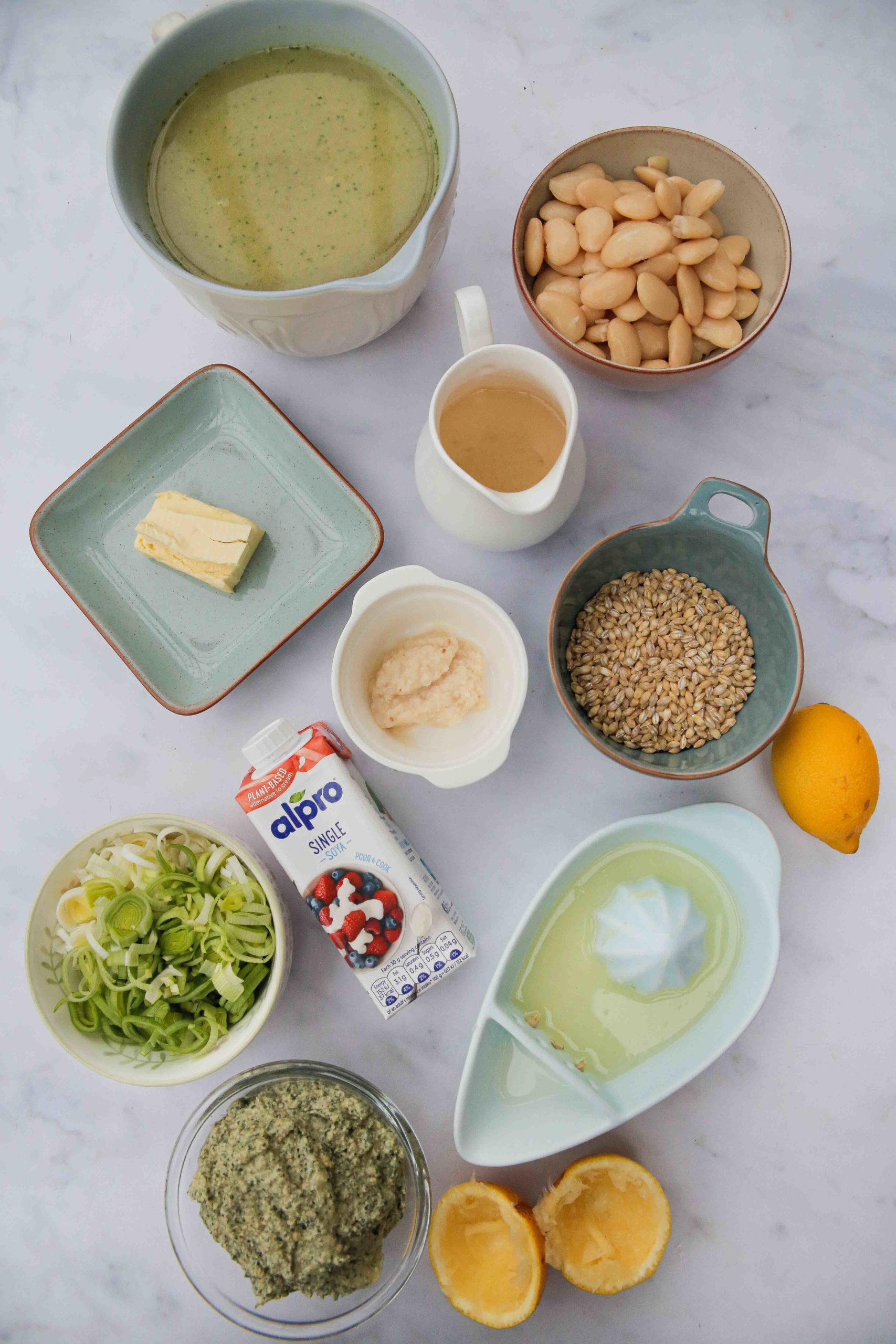 This rich and creamy white bean soup with leeks, pearl barley and pesto is so easy to make - just one pan needed - and full of hearty delicious flavours! Recipe on thecookandhim.com #vegansoup #whitebeansoup #vegansouprecipe