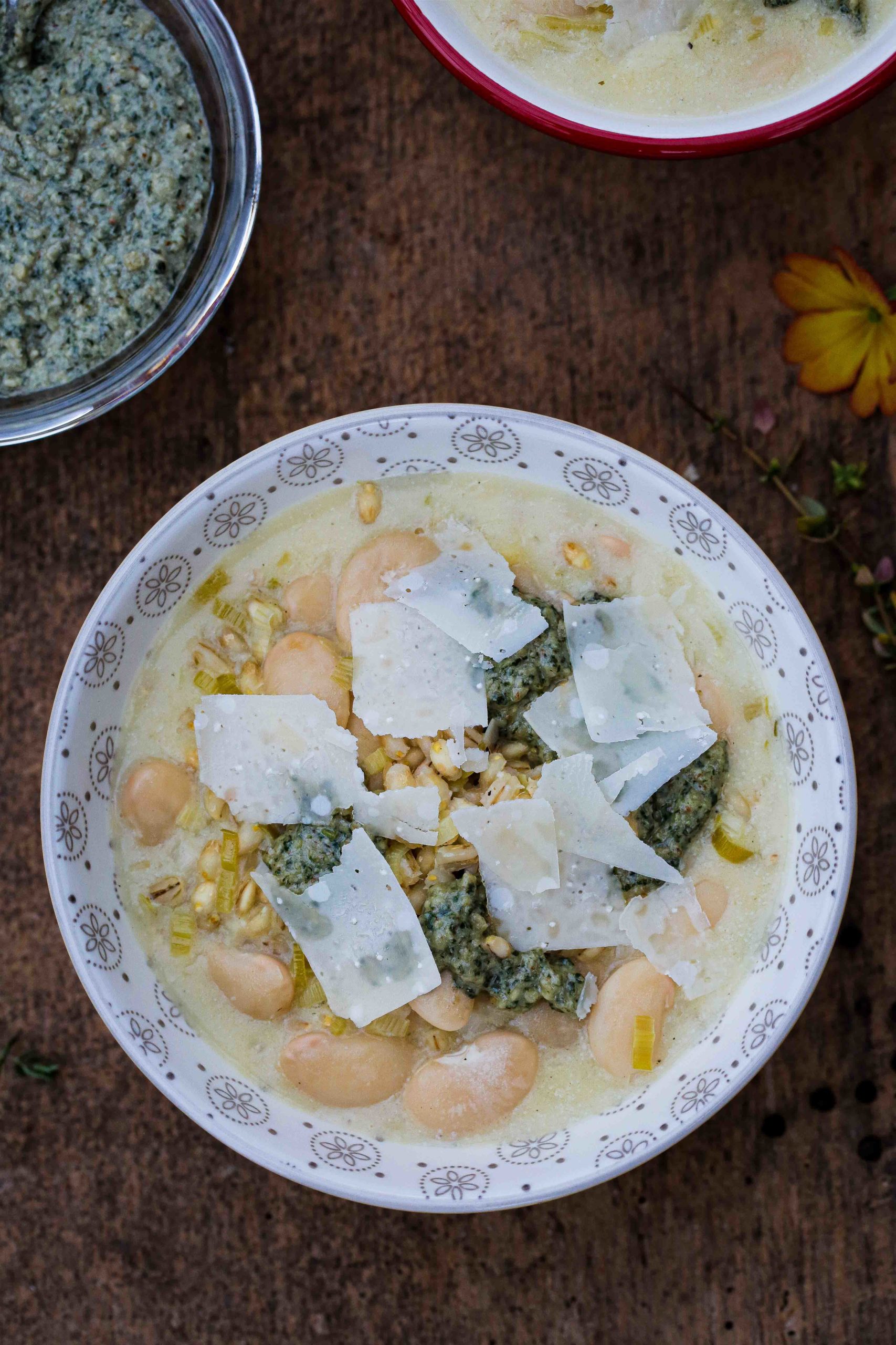 This rich and creamy white bean soup with leeks, pearl barley and pesto is so easy to make - just one pan needed - and full of hearty delicious flavours! Recipe on thecookandhim.com #vegansoup #whitebeansoup #vegansouprecipe