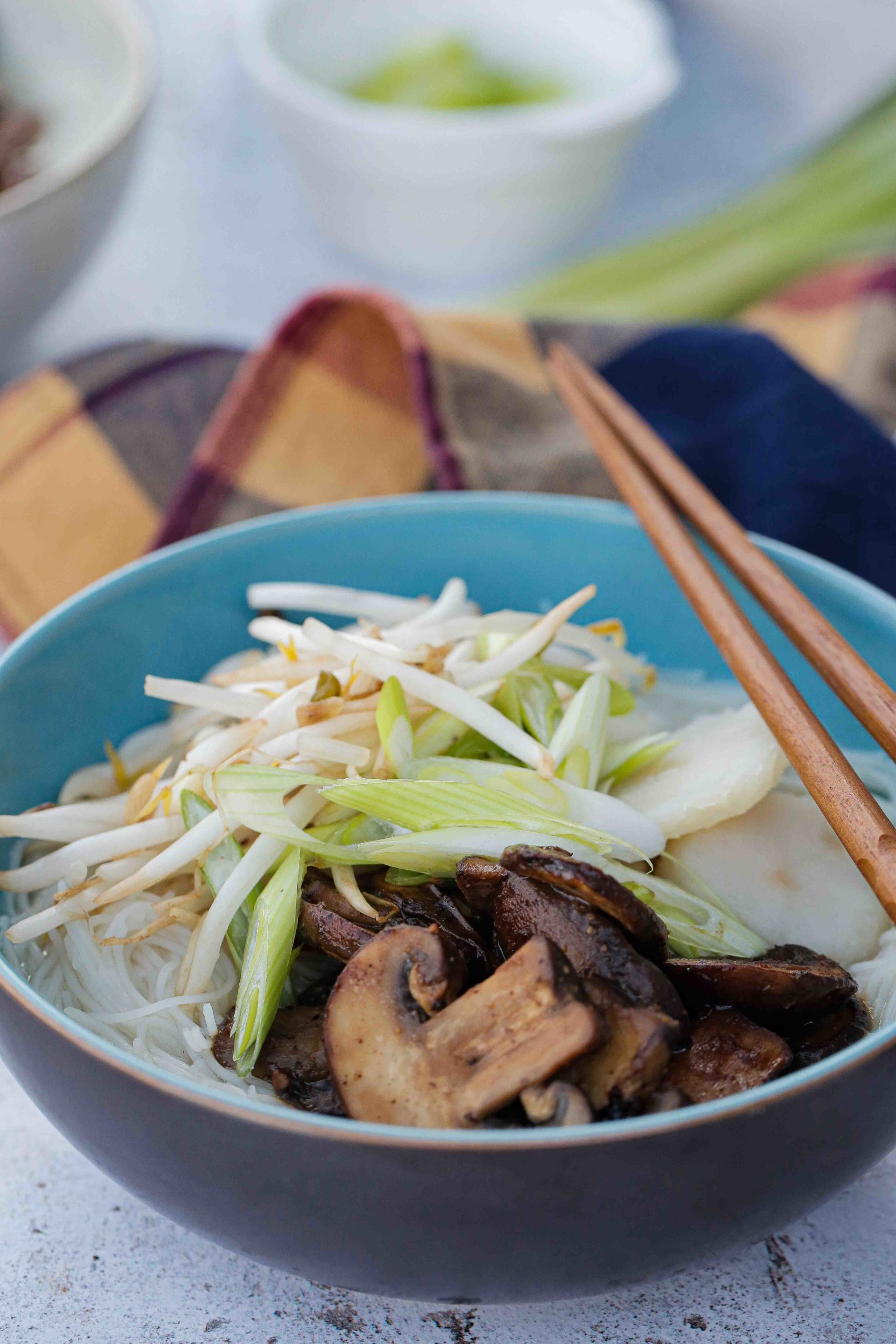 This gently spiced vegan noodle soup is full of bright fresh flavours and topped with rich umami mushrooms | Recipe on the cookandhim.com #noodlesoup #asianfood #vegan #easyveganrecipe