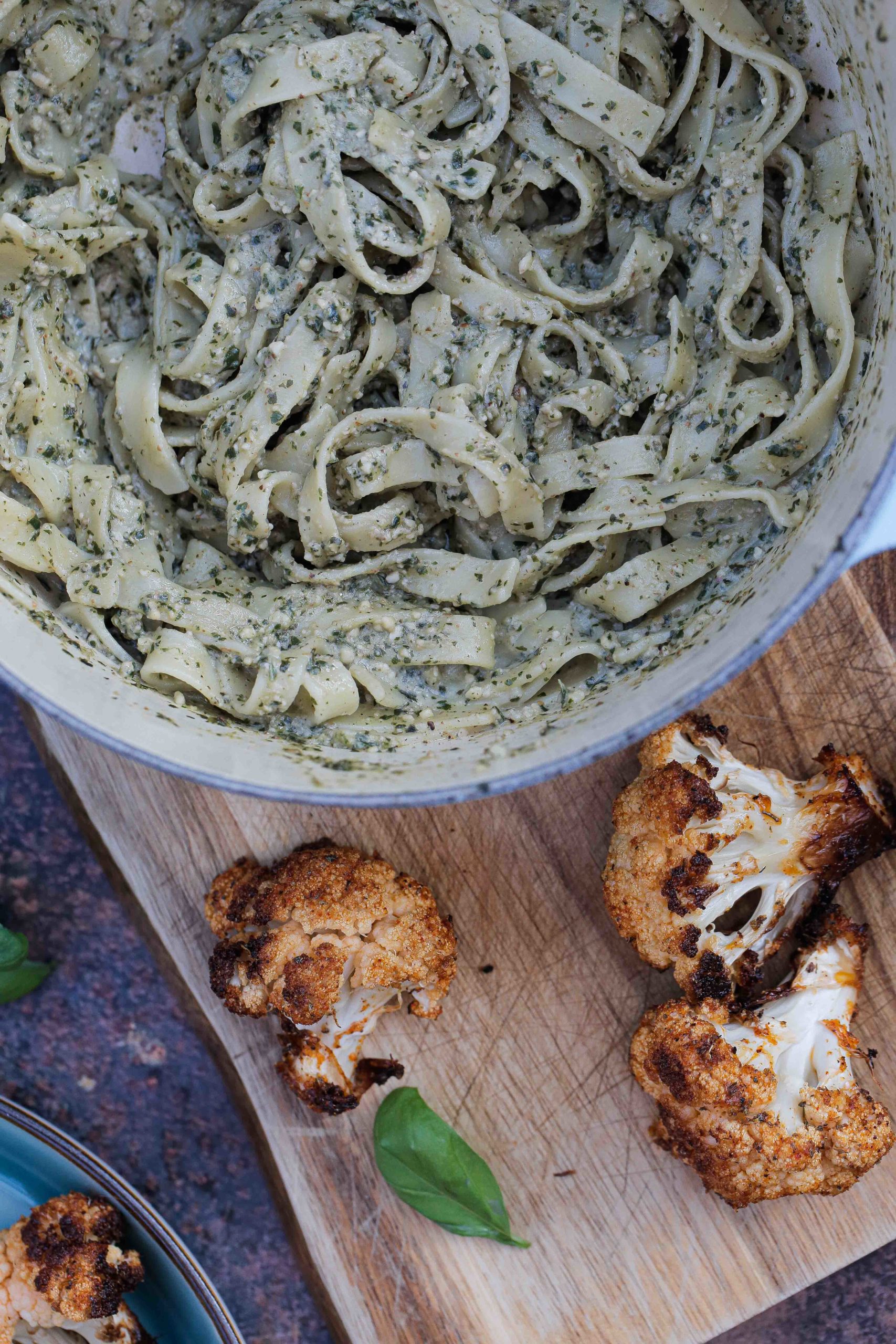 Herby basil pesto stirred through tagliatelle and topped with lightly spiced crispy roast cauliflower. A lovely contrast of textures and flavours that work perfectly together for an easy weeknight meal or date night deliciousness! Recipe on thecookandhim.com | #veganpesto #roastcauliflower #veganmeal #vegandinner #cauliflowerrecipes