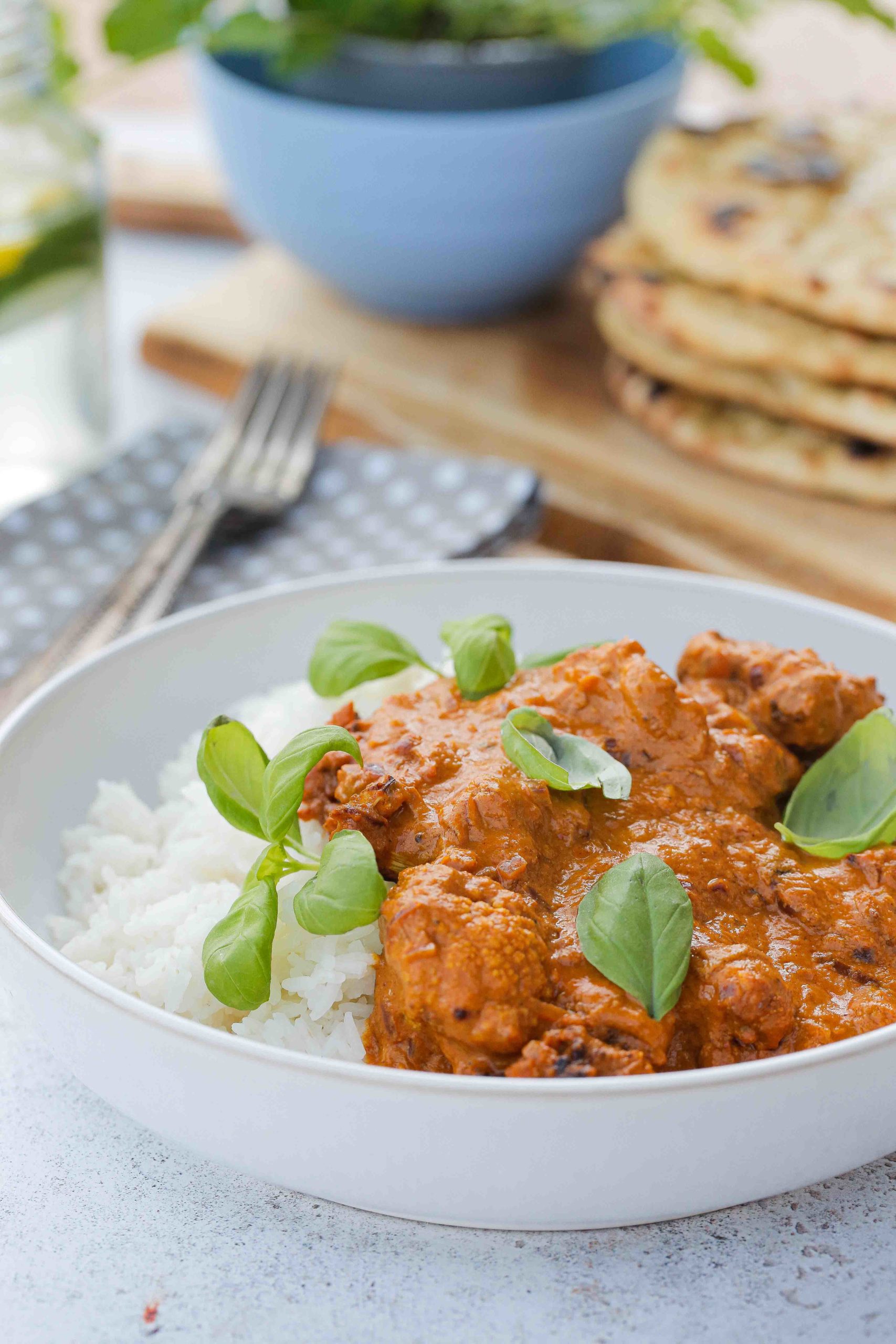 This vegan cauliflower curry in a creamy, spicy tomato sauce is easy to make with simple ingredients and so delicious! Serve with rice and homemade naan bread for a healthy and tasty vegan meal! Recipe on thecookandhim.com | #vegancurry #cauliflowercurry #veganbutterchicken #veganrecipes #homemadecurry