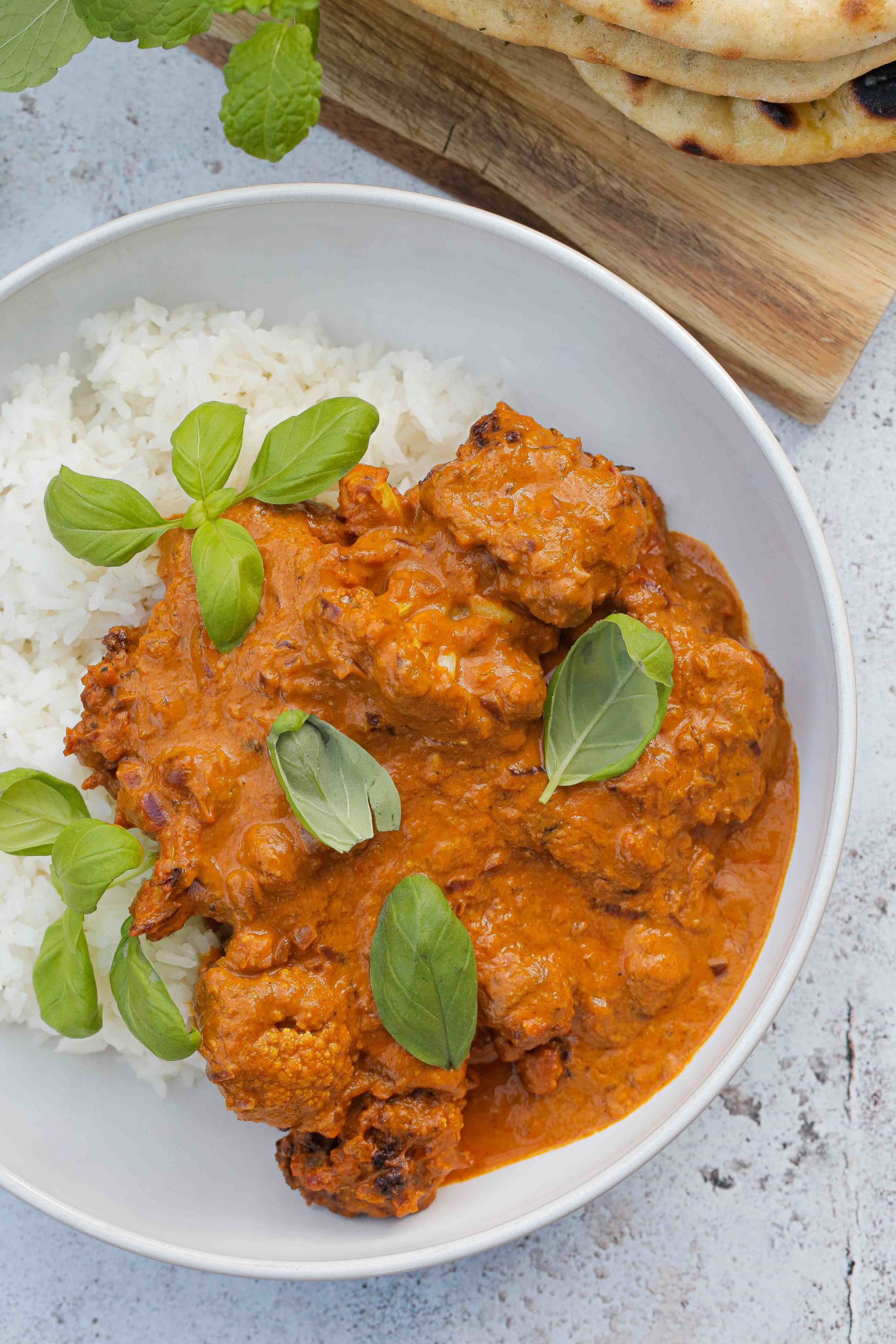 This vegan cauliflower curry in a creamy, spicy tomato sauce is easy to make with simple ingredients and so delicious! Serve with rice and homemade naan bread for a healthy and tasty vegan meal! Recipe on thecookandhim.com | #vegancurry #cauliflowercurry #veganbutterchicken #veganrecipes #homemadecurry