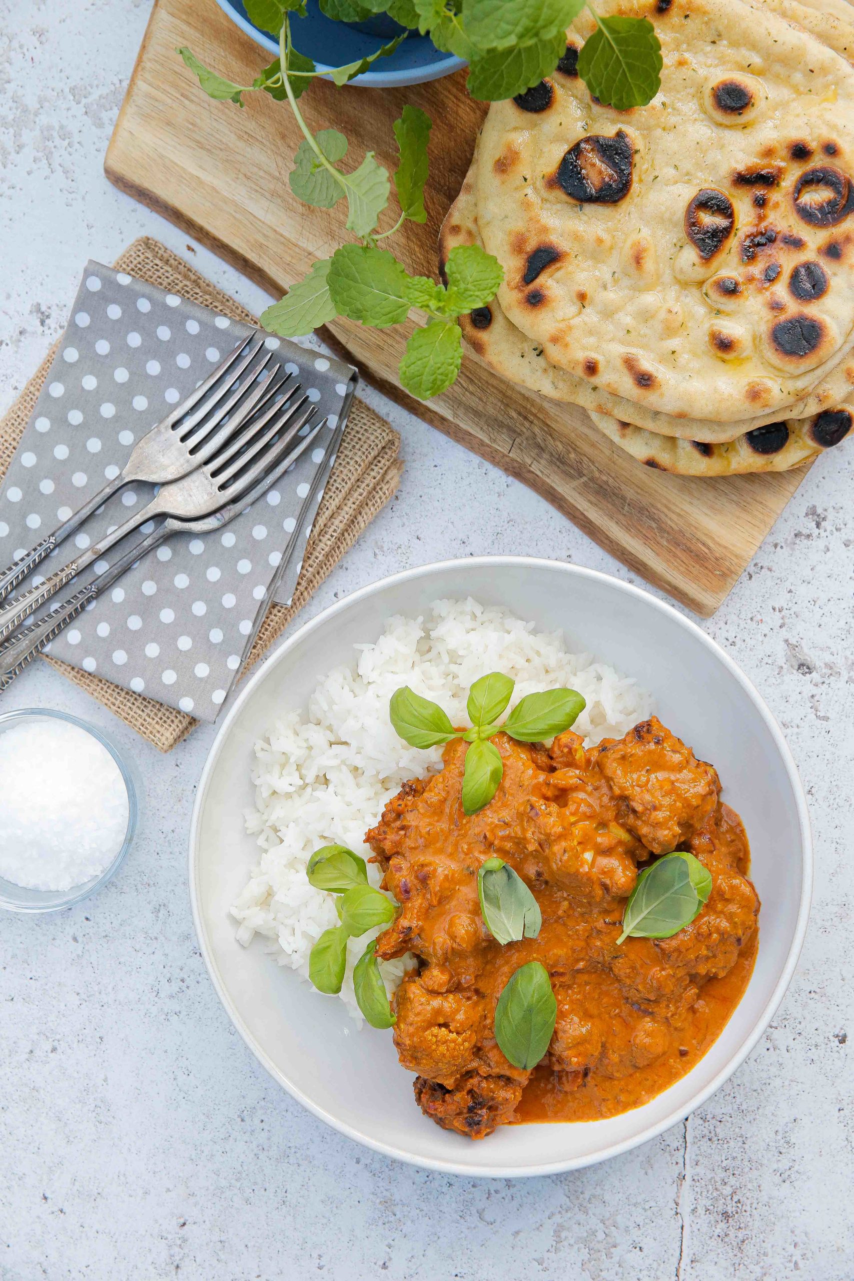 This vegan cauliflower curry in a creamy, spicy tomato sauce is easy to make with simple ingredients and so delicious! Serve with rice and homemade naan bread for a healthy and tasty vegan meal! Recipe on thecookandhim.com | #vegancurry #cauliflowercurry #veganbutterchicken #veganrecipes #homemadecurry