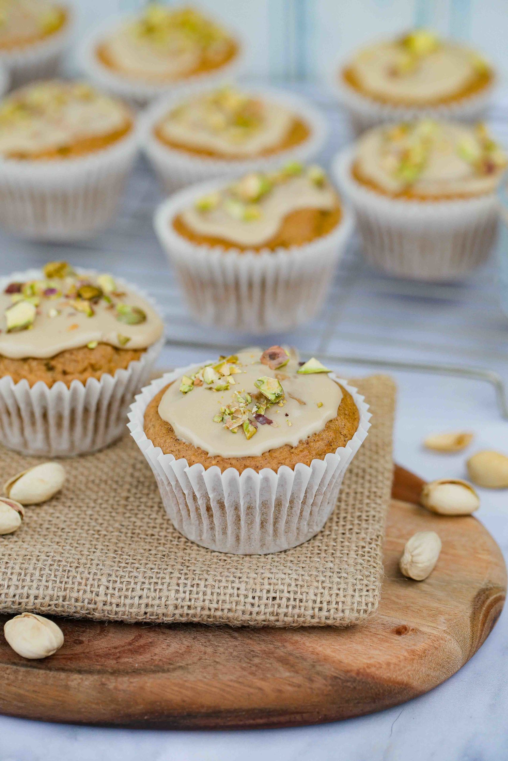 Delicious and super easy vegan carrot cake muffins with all the spice and flavour of carrot cake just in a more portable form! Topped with a lovely lemon icing and chopped pistachios. Enjoy with your morning coffee or as an afternoon treat. Recipe on thecookandhim.com | #carrotmuffins #carrotcakemuffins #muffinrecipe #veganmuffins #snack #vegansnacks