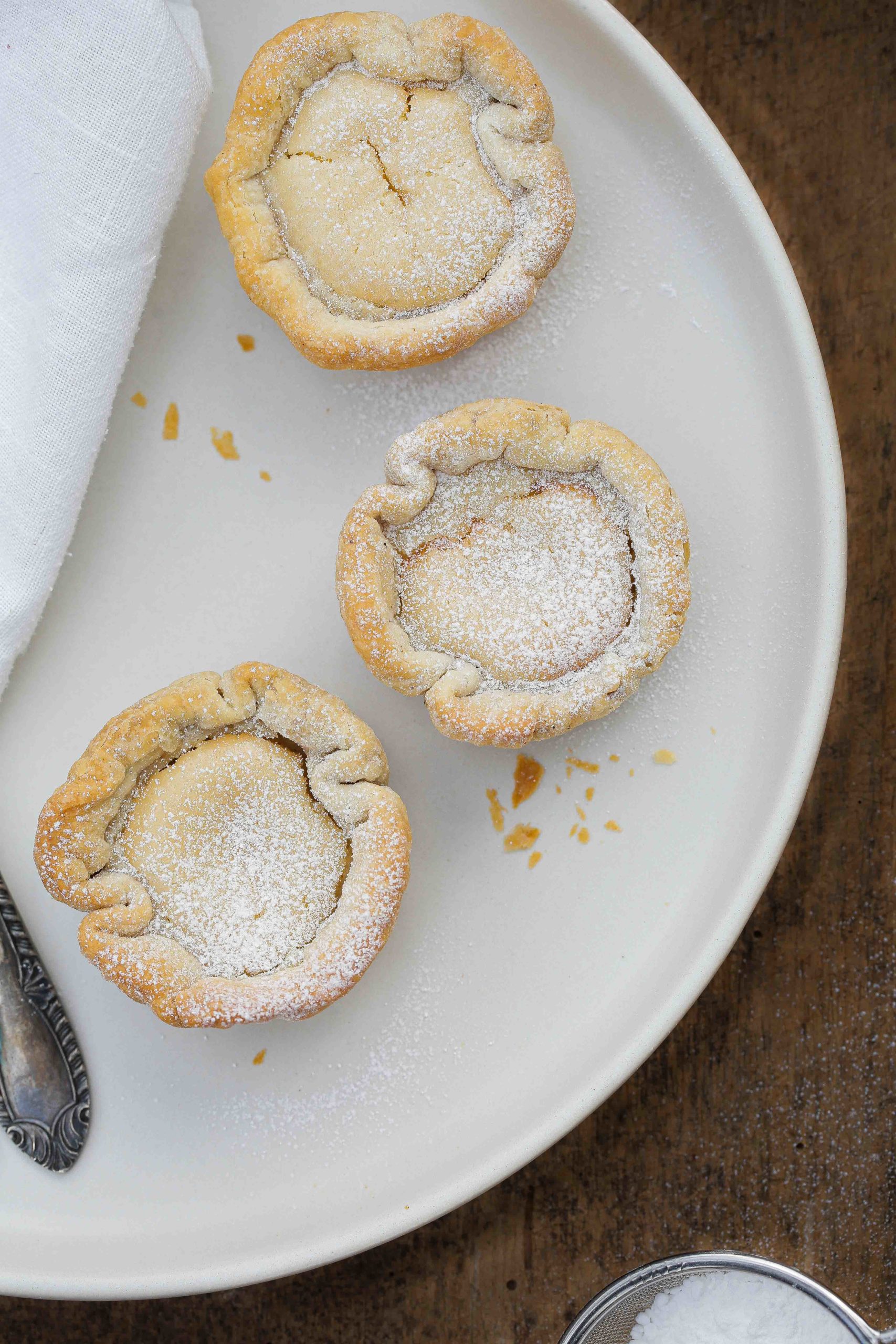 No plane ticket required for these Portuguese custard tarts! Creamy vegan custard is housed in a crisp puff pastry shell before being baked to golden perfection. Recipe in thecookandhim.com | #vegancustard #portuguesecustardtart #eggfreecustard #pasteldenata #tofurecipes