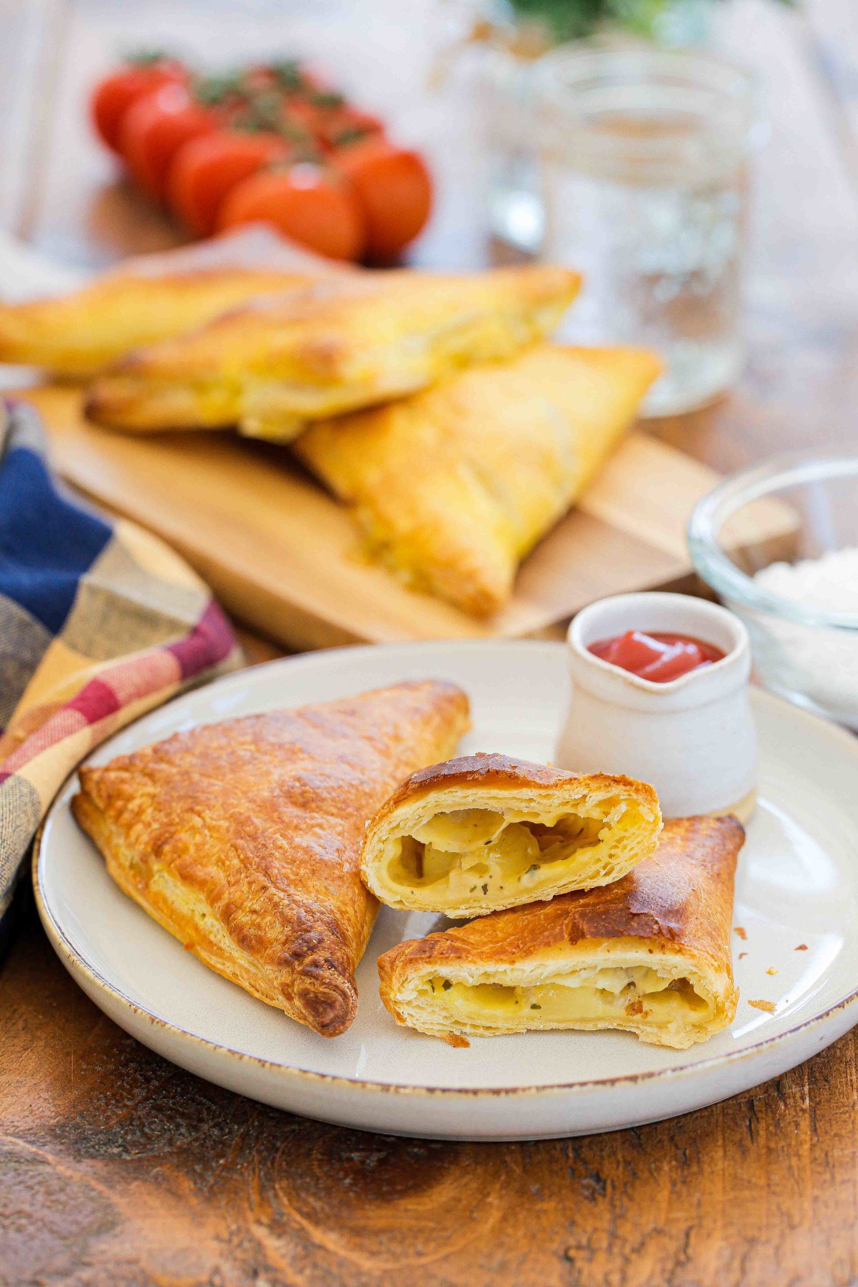 These delicious little cheese and potato pies make a handy midweek meal but are also perfect for lunchboxes and picnics. Serve hot or cold and freeze any extras for a quick meal another day! Recipe on thecookandhim.com | #cheeseandpotatopie #puffpastry #pasties #vegan #vegancheese #vegetarian