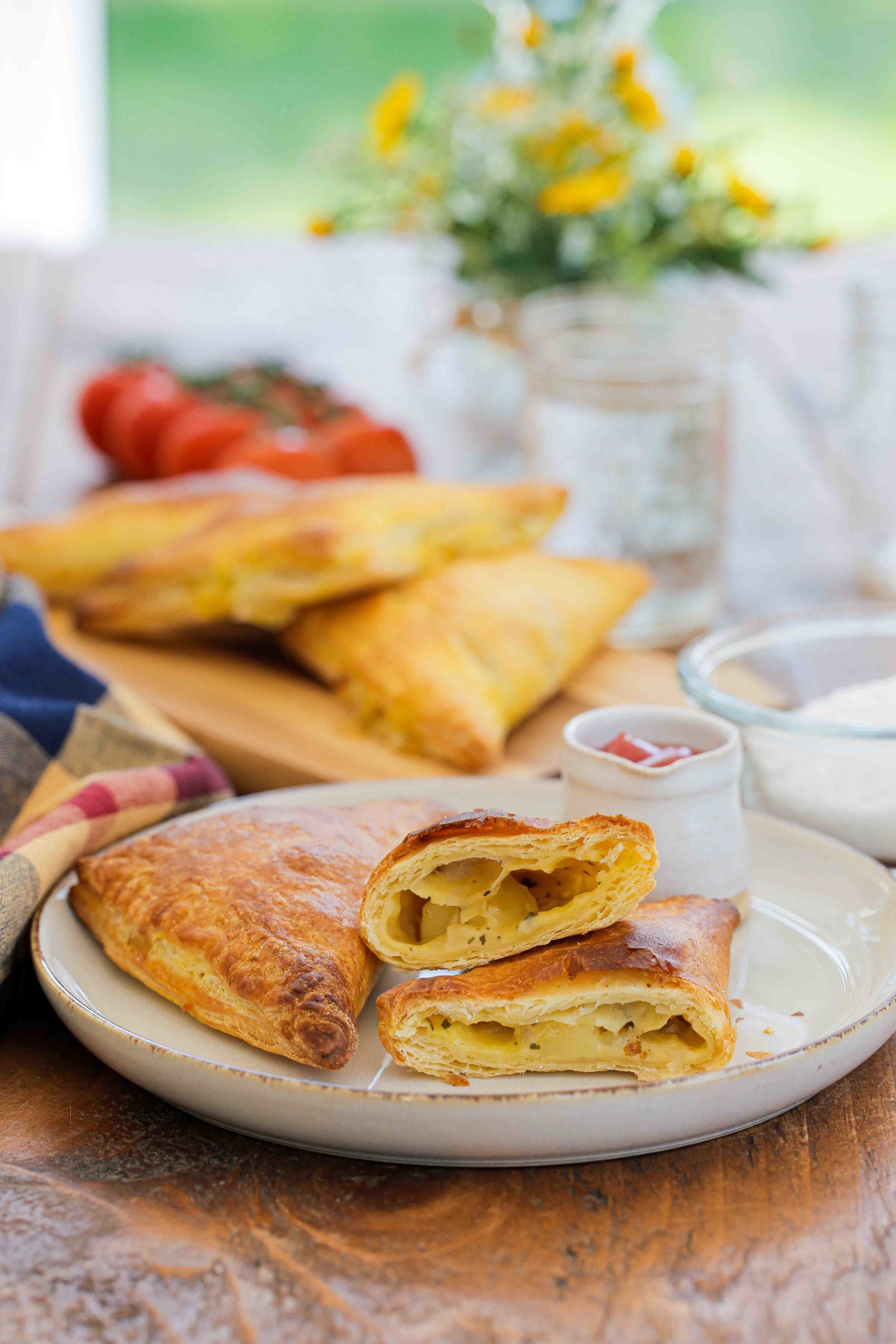 These delicious little cheese and potato pies make a handy midweek meal but are also perfect for lunchboxes and picnics. Serve hot or cold and freeze any extras for a quick meal another day! Recipe on thecookandhim.com | #cheeseandpotatopie #puffpastry #pasties #vegan #vegancheese #vegetarian