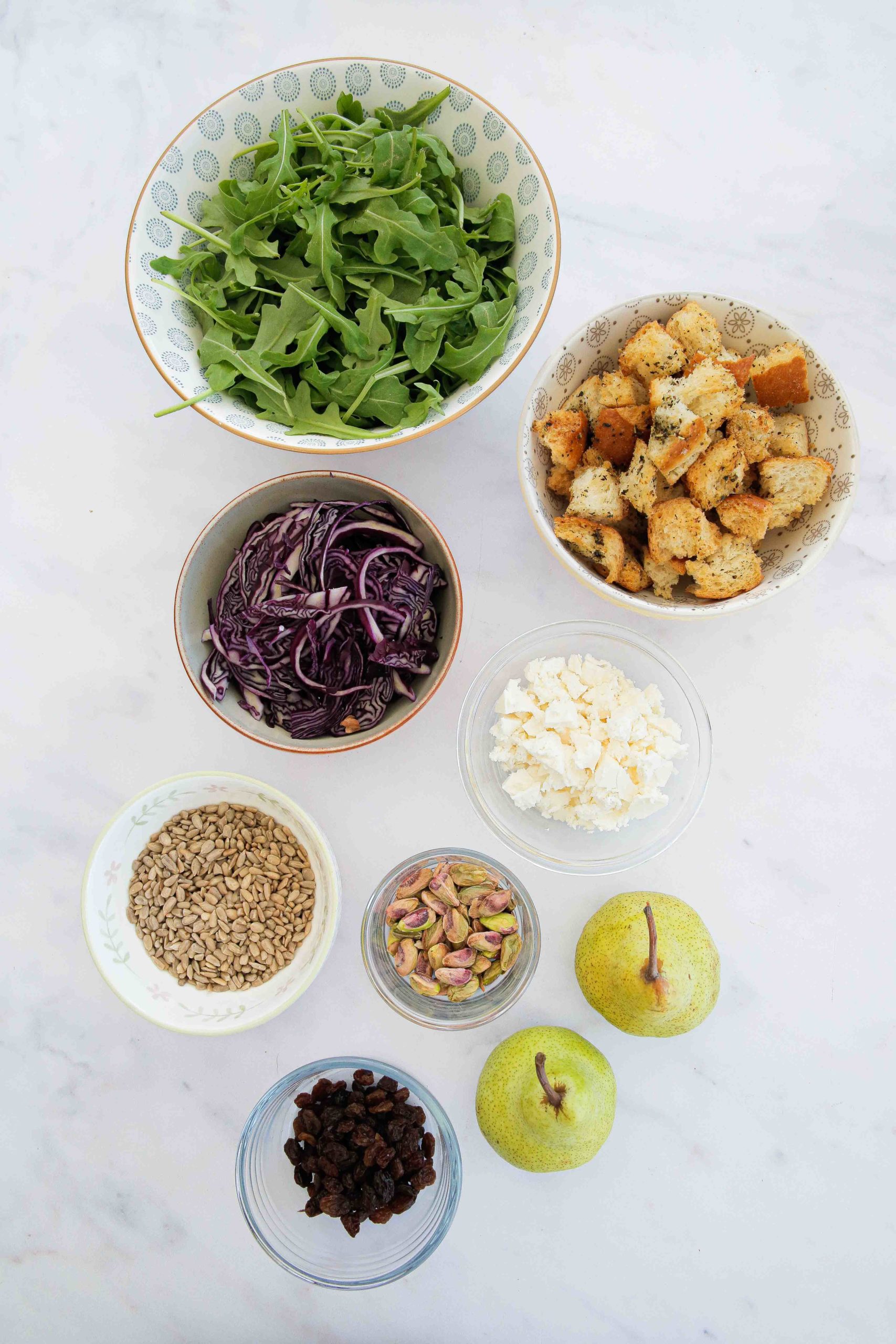 This pear salad will easily become a seasonal favourite! Made with roasted pears, red cabbage, homemade croutons and a tangy mustard dressing. Recipe on thecookandhim.com #pearsalad #redcabbage #arugula #rocket #stalebread #homemadecroutons