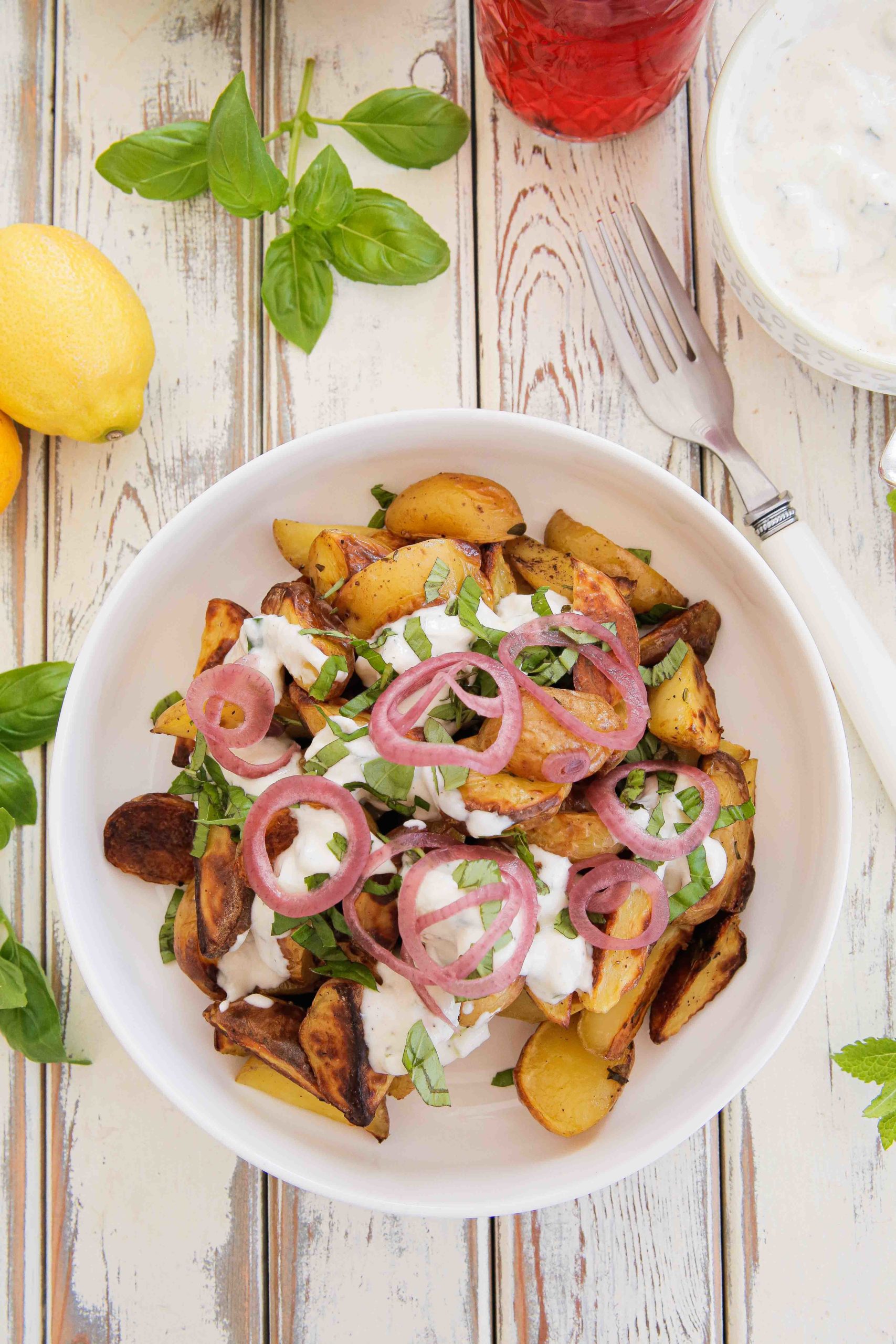 Perfect for your al fresco feast this roasted new potato salad is a full step up from a traditional potato salad. The potatoes are roasted with lemon and herbs and served with vegan tzatziki and quick pickled onions. Recipe on thecookandhim.com #roastednewpotatosalad #pickledredonion #tzatziki #summersalad #alfrescofood #picnicfood #bbqsides #summerlunchideas #vegansalad #potatosalad