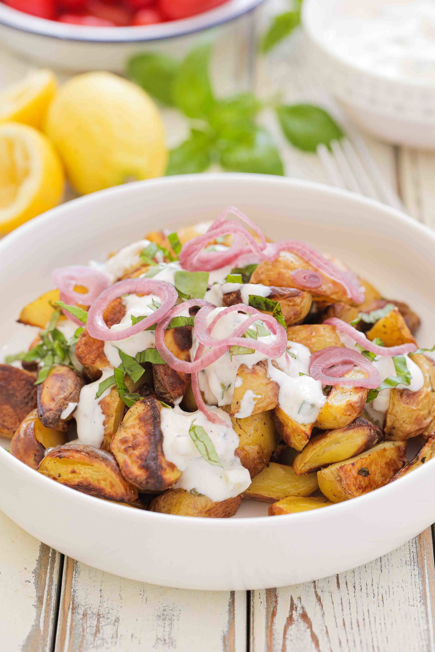 Perfect for your al fresco feast this roasted new potato salad is a full step up from a traditional potato salad. The potatoes are roasted with lemon and herbs and served with vegan tzatziki and quick pickled onions. Recipe on thecookandhim.com #roastednewpotatosalad #pickledredonion #tzatziki #summersalad #alfrescofood #picnicfood #bbqsides #summerlunchideas #vegansalad #potatosalad