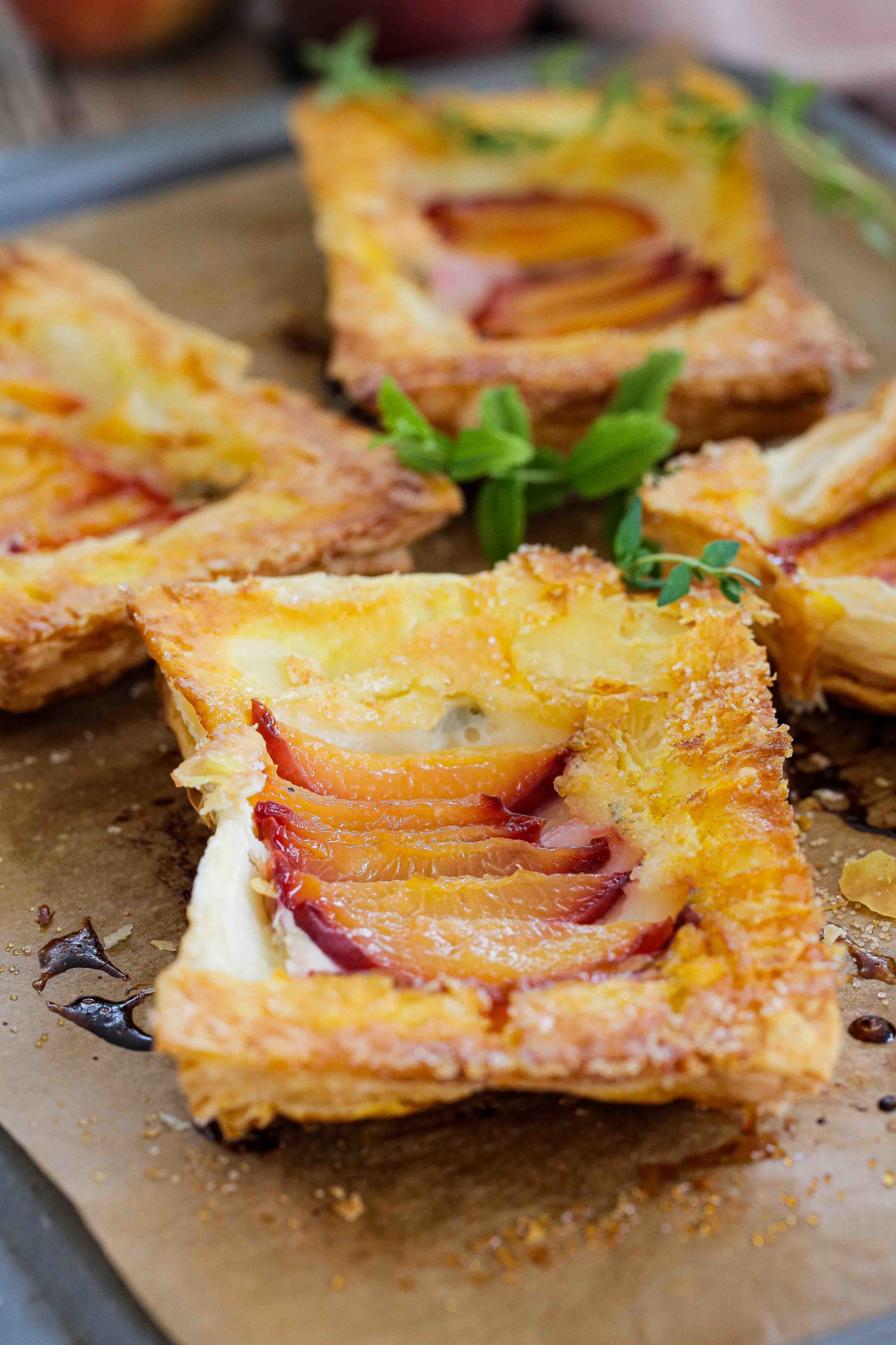 Delicious vegan desserts don't come any easier than these peach upside down tarts. The herb cream cheese adds even more garden fresh flavour! Recipe on thecookandhim.com | #vegandessertrecipes #veganpastries #upsidedowntarts #creamcheesetarts #puffpastry