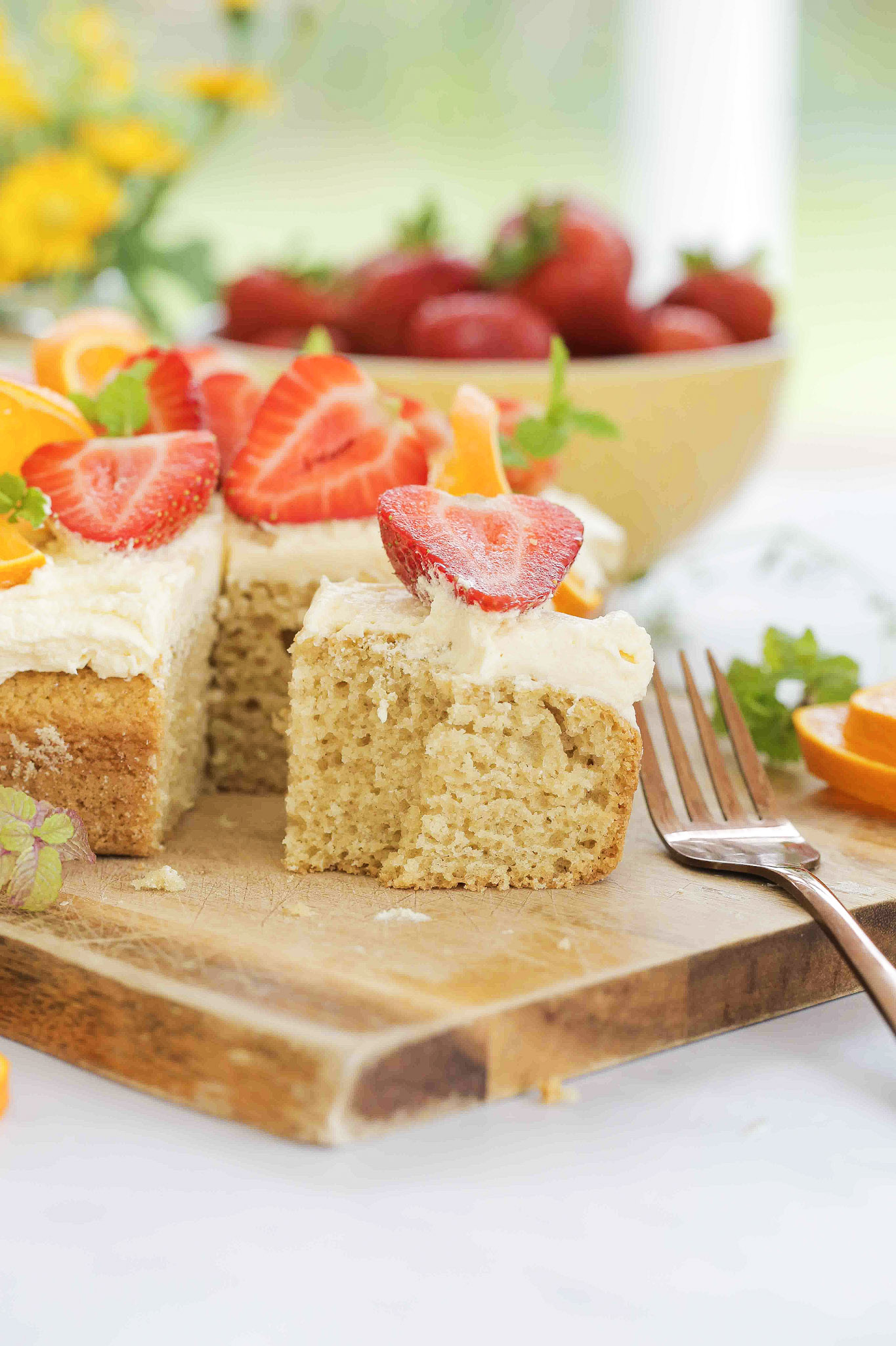 Soft and fluffy vegan vanilla sheet cake or tray bake is an easy buttery sponge, topped with whipped icing and fresh fruit. Perfect for birthdays, afternoon tea or simply because! Recipe on thecookandhim.com #vanillacake #vegancake #veganvanillacake #birthdaycake #sheetcake #traybakecake #veganfrosting
