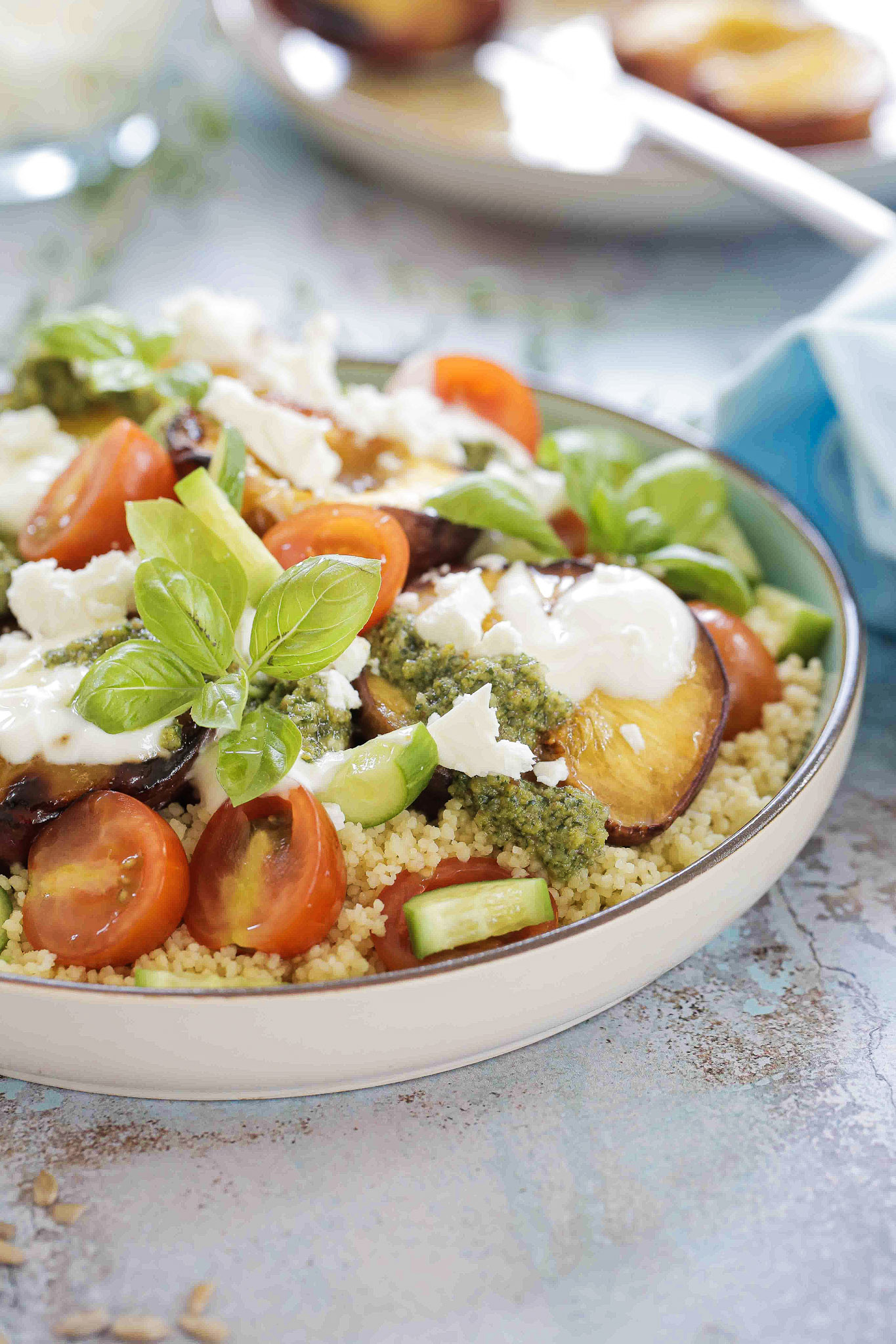 Summery Mediterranean Couscous Salad bursting with flavour! Fresh summer veggies, pesto, roast peaches, vegan yoghurt and feta all combine in this easy summer salad. Recipe on thecookandhim.com #summersalad #couscousrecipes #couscoussalad #healthydinner #summermeals #saladrecipes #picnicfood #moroccanfood